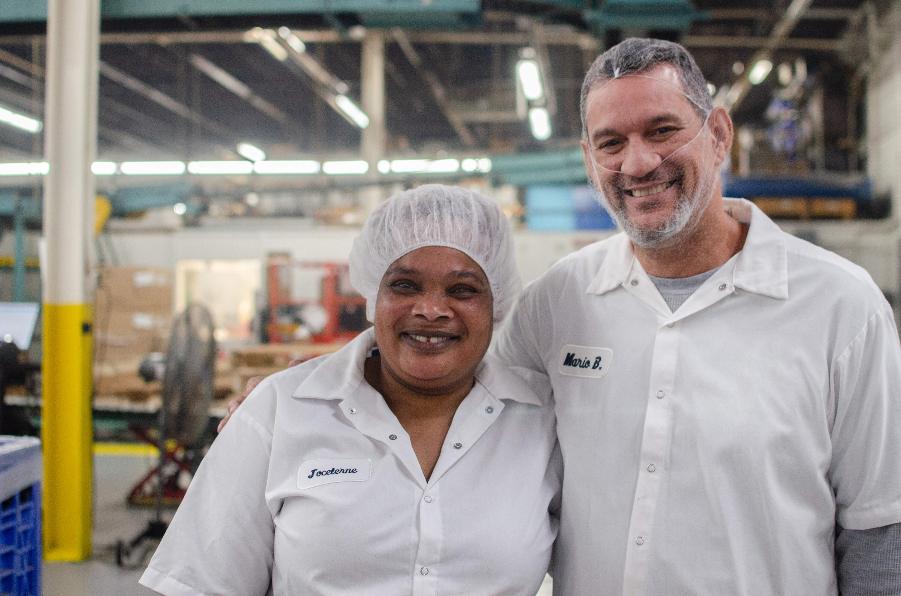 Jocelerne Florvil, of Chelsea, has worked at Teddie for about 12 years and was recently promoted to line operator. Her supervisor, Mario Barriera, from Lowell, is the production manager for the first shift and has been with Teddie for about 15 years. (Sharon Brody/WBUR)