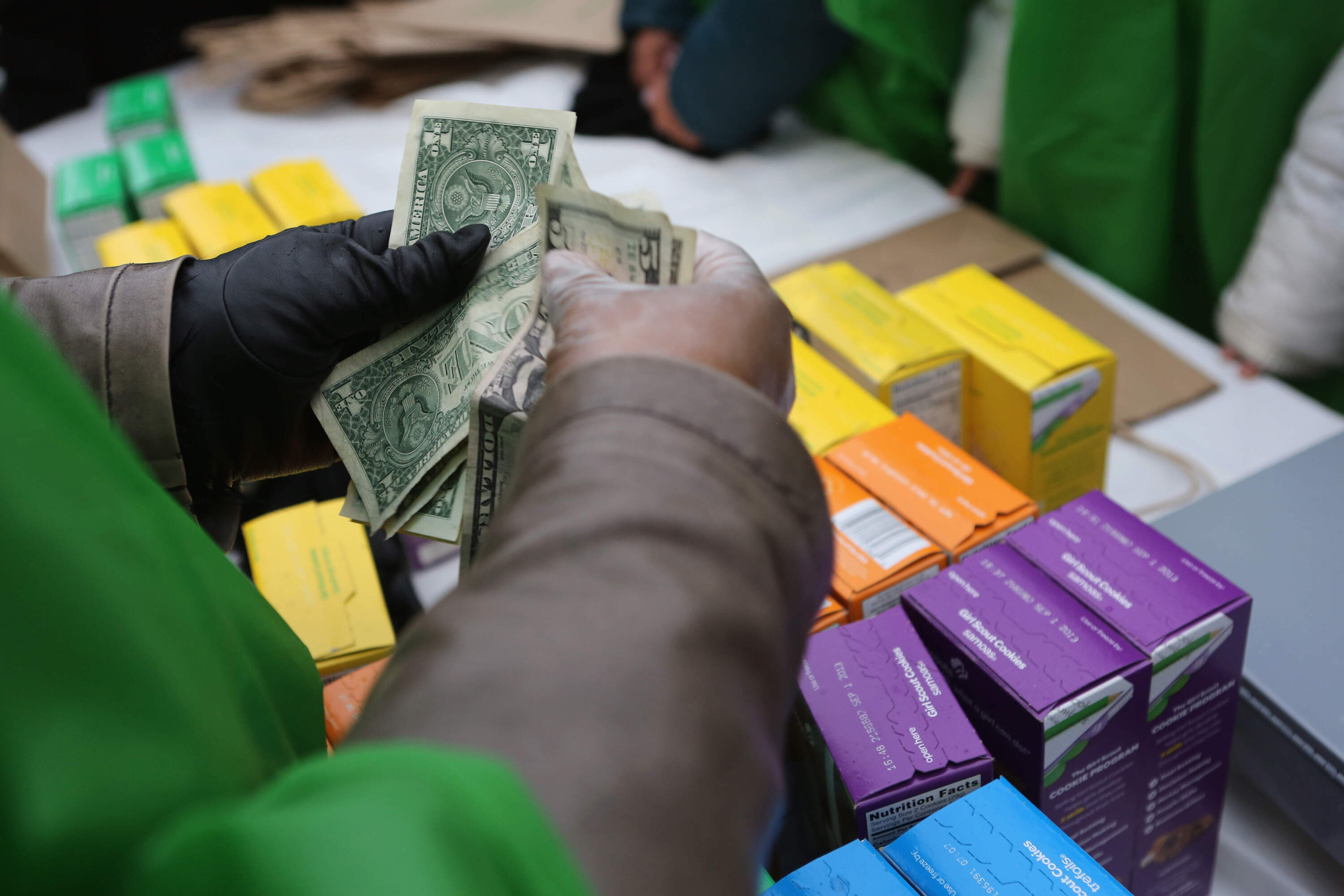 Money is collected as Girl Scouts sell cookies. (John Moore/Getty Images)