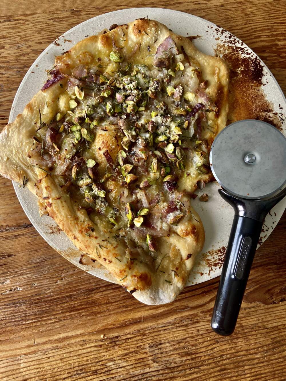 Red onion, rosemary, parmesan and pistachio pizza. (Kathy Gunst/Here & Now)
