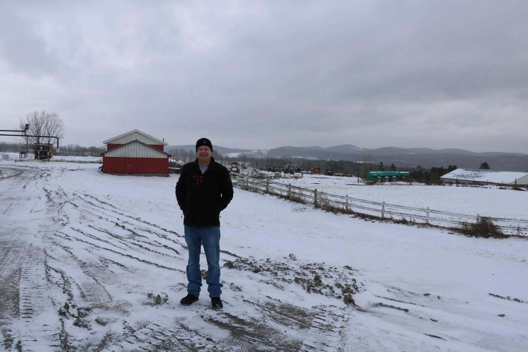 Matt Maxwell stands on his family's farm in Coventry. The land behind Maxwell was rented out to Phish for the 2004 two-day music festival. (Howard Weiss-Tisman/Vermont Public)