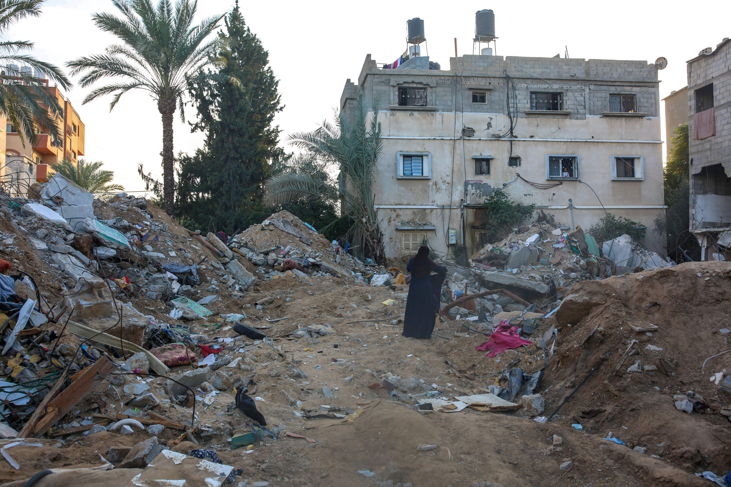 Melisya’s aunt, Yasmine, at the site of the girl’s destroyed family home. (Samar Abu Elouf/New York Times)