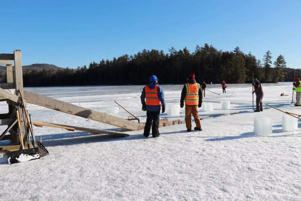 Harvesters use a variety of old, wooden tools used to cut, move, and pack the ice into small shelters, where it stays packed in sawdust throughout the summer. As people move around the ice, the warming sun sometimes causes small cracks to form. (Zoey Knox/NHPR)