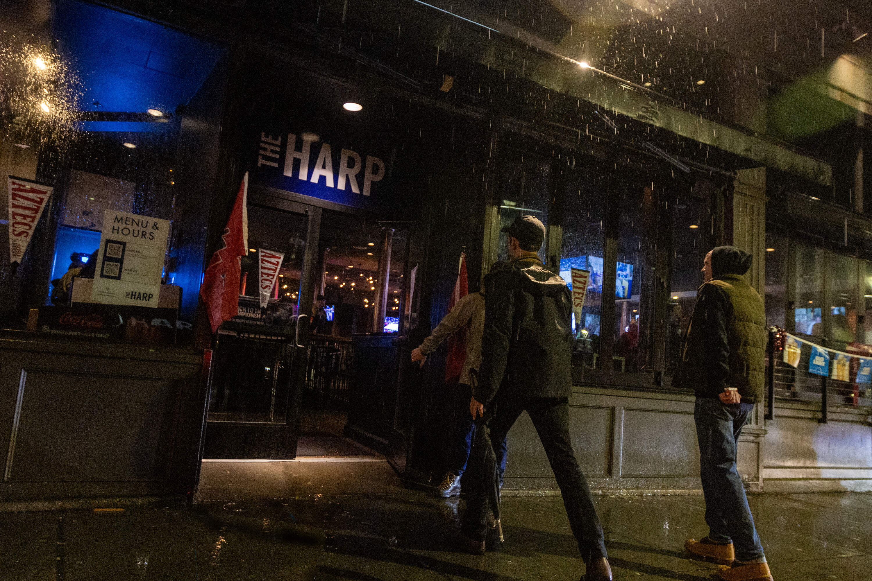 Men walk into the Harp, a popular sports bar near Boston's TD Garden. This was the tavern where prosecutors say two victims of sexual assault encountered Campbell in 2017. Campbell allegedly posed as a bouncer there and offered them a ride. Another woman accused Campbell of raping her after giving her a ride from the same bar two years later. (Jesse Costa/WBUR)