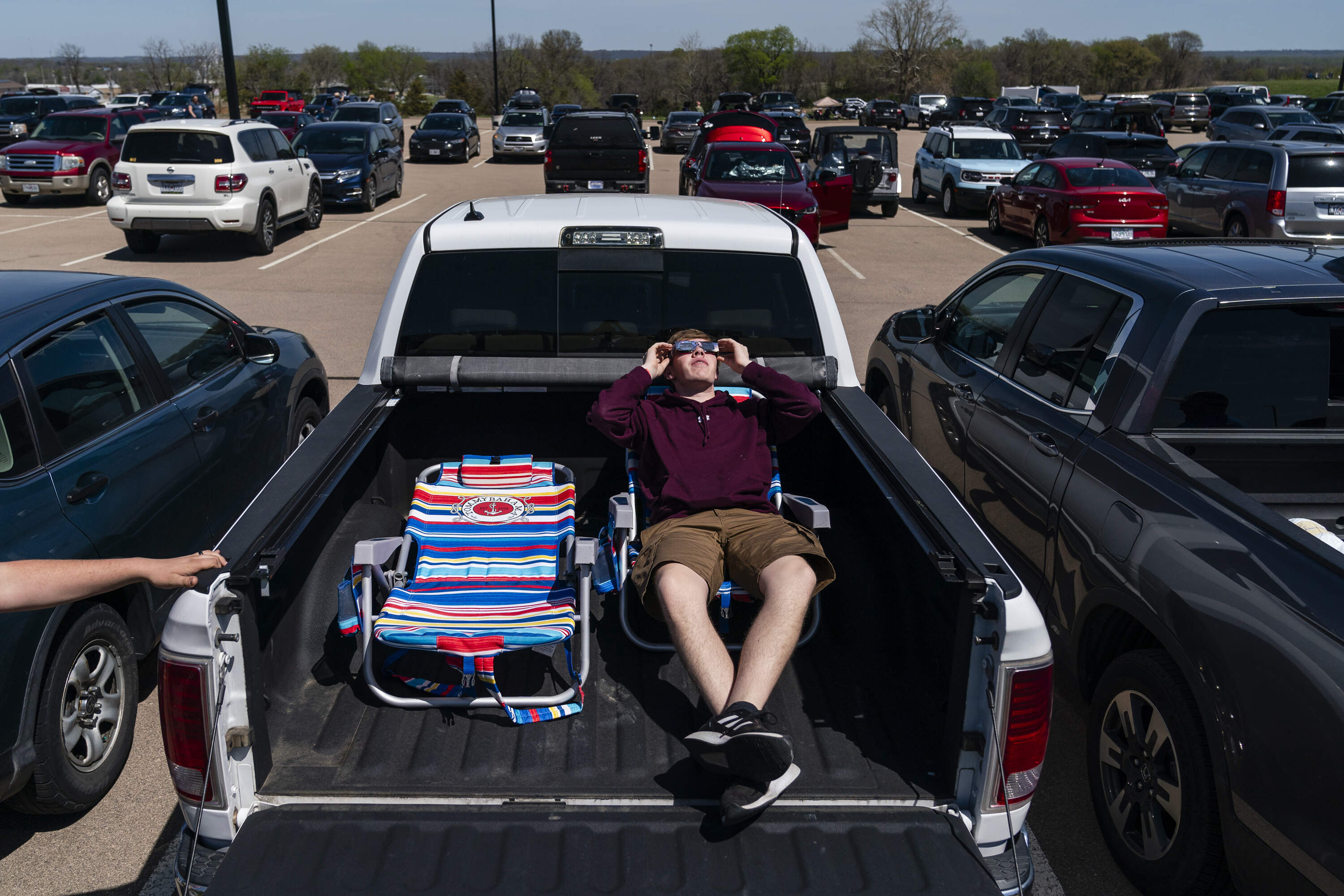 Ben Estes, 18, looks at the sun through solar eclipse glasses on Monday, April 8, 2024, at the Ste. Genevieve, Missouri. (Eric Lee/STLPR)