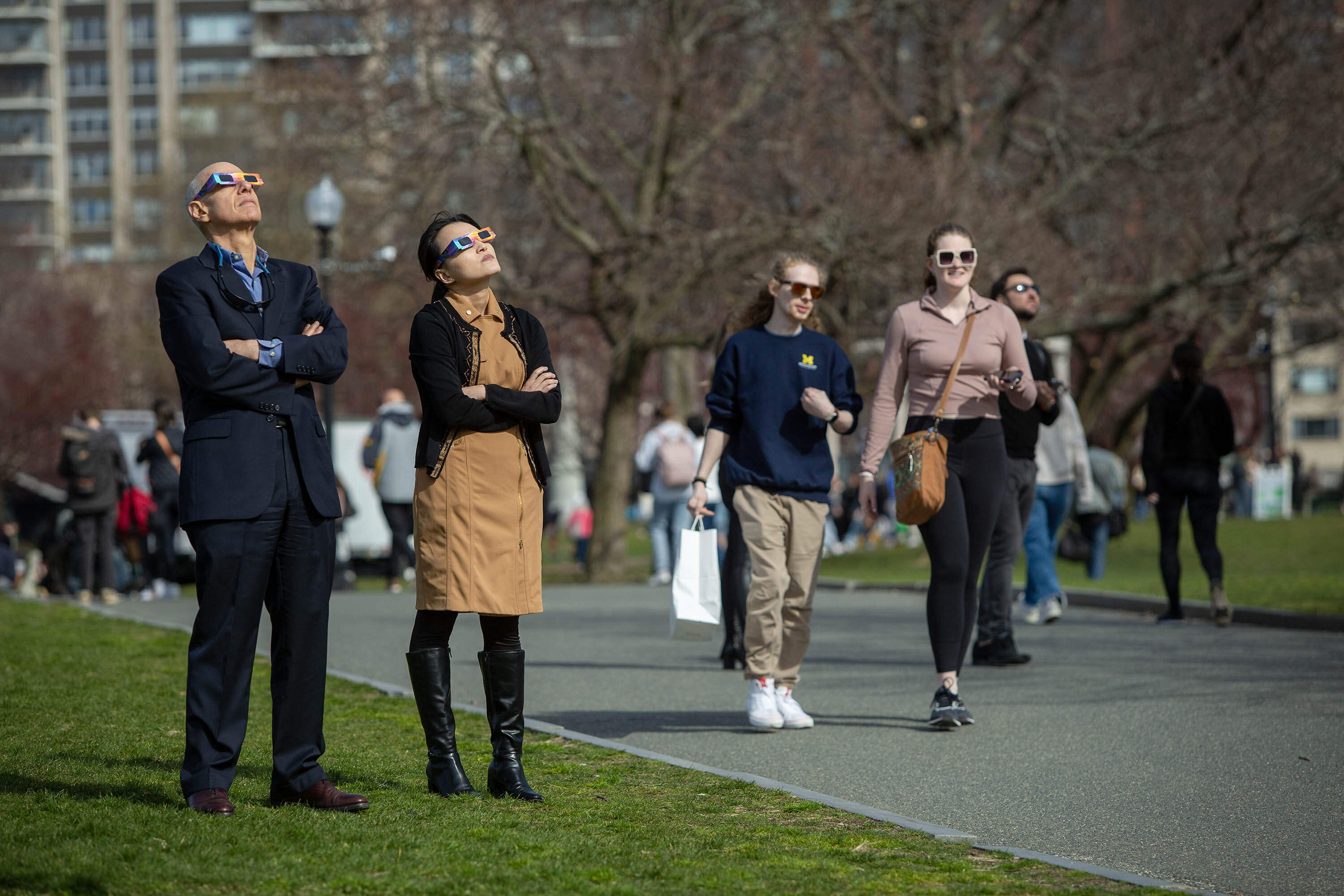 With the eclipse winding down some people start to leave Boston Common, while others linger to watch the moon's departure. (Robin Lubbock/WBUR)