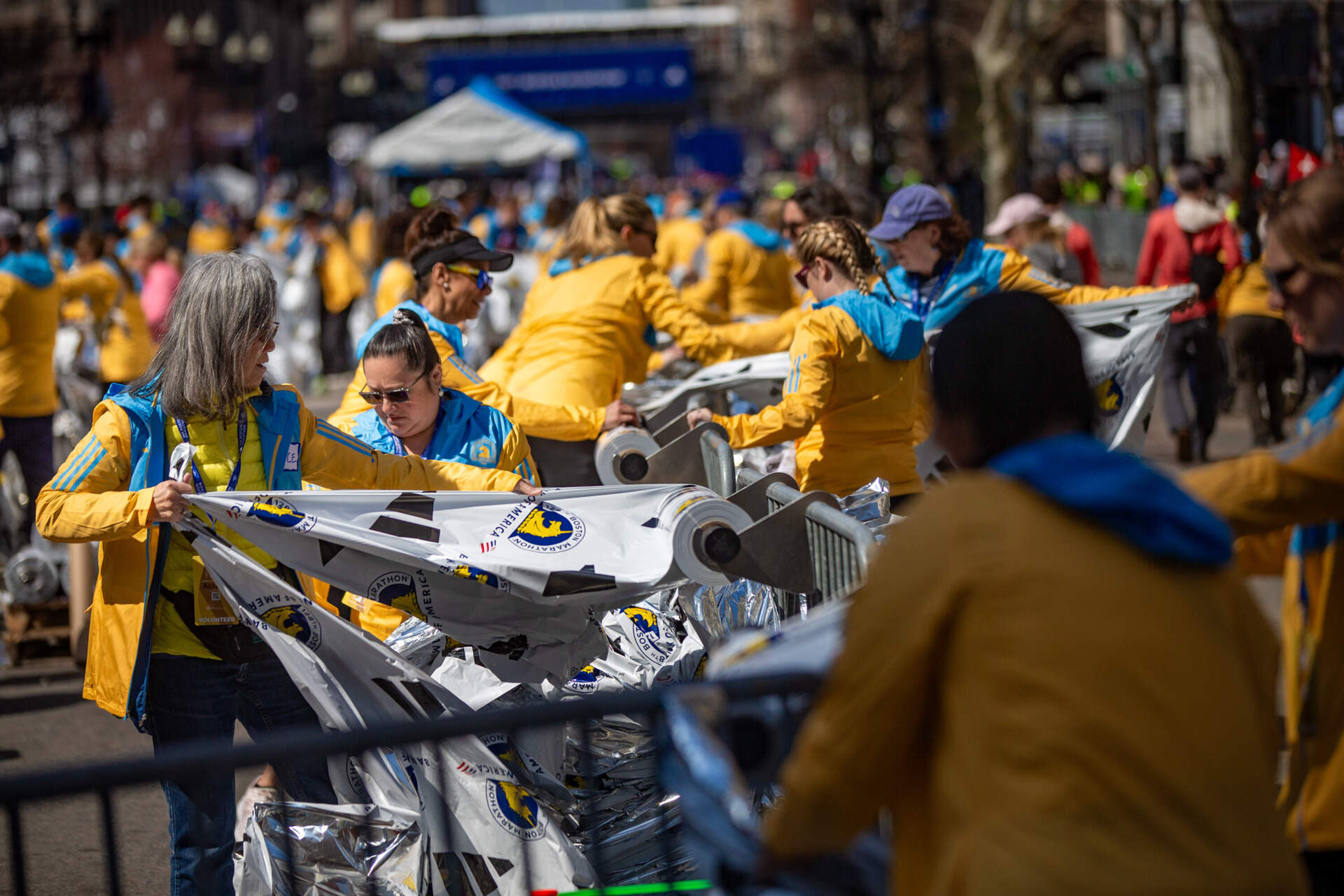 Volunteers prepare foil blankets for runners after they complete the race. (Jesse Costa/WBUR)