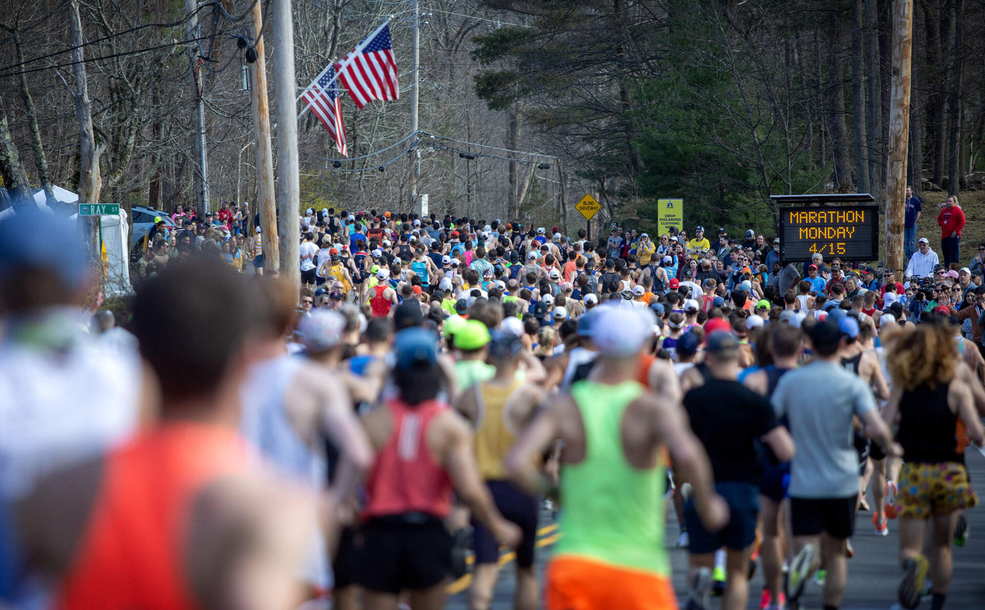 Marathon runners race down the hill on their way out of Hopkinton Monday morning. (Robin Lubbock/WBUR)