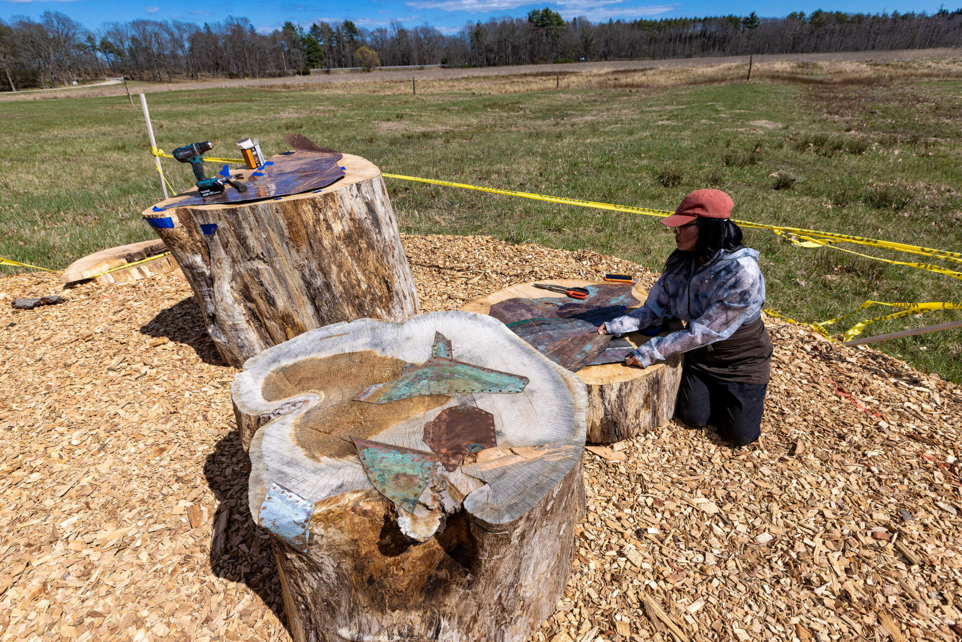 Artist Jean Shin works on one of the human perches of her exhibit at Appleton Farms, “Perch.” (Jesse Costa/WBUR)
