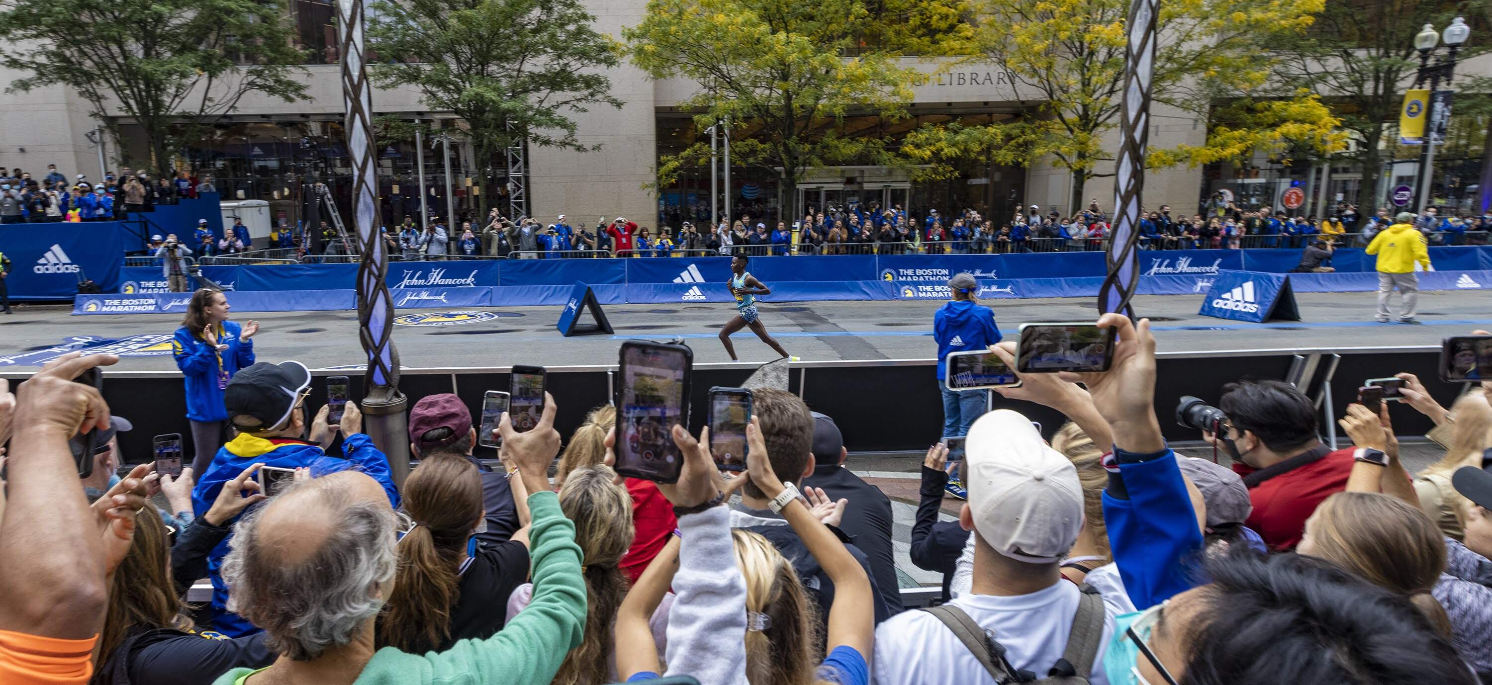 Fans cheer along Boyston Street as Diana Kipyogei approaches the finish line at the 2021 Boston Marathon. (Jesse Costa/WBUR)