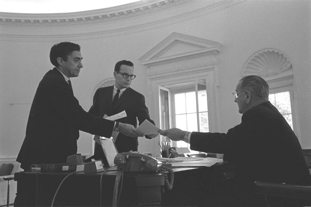 Dick Goodwin and White House aide Bill Moyers peering over President Lyndon B. Johnson’s desk in the Oval Office to see the edits the president is making on a speech draft. In the second picture, Johnson is handing the pages back when the edits were completed, May 4, 1965. (Yoichi Okamoto/Courtesy of LBJ Library)