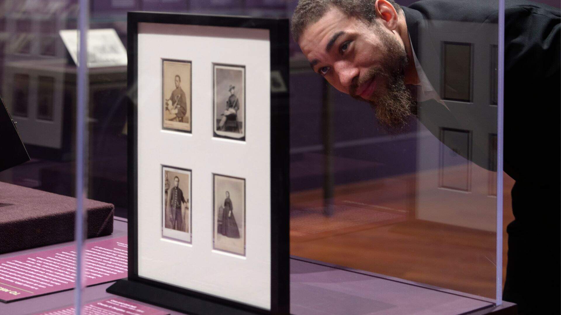 A visitor looks at several cartes-de-visites. (Courtesy Tony Rinaldo/Boston Athenaeum)