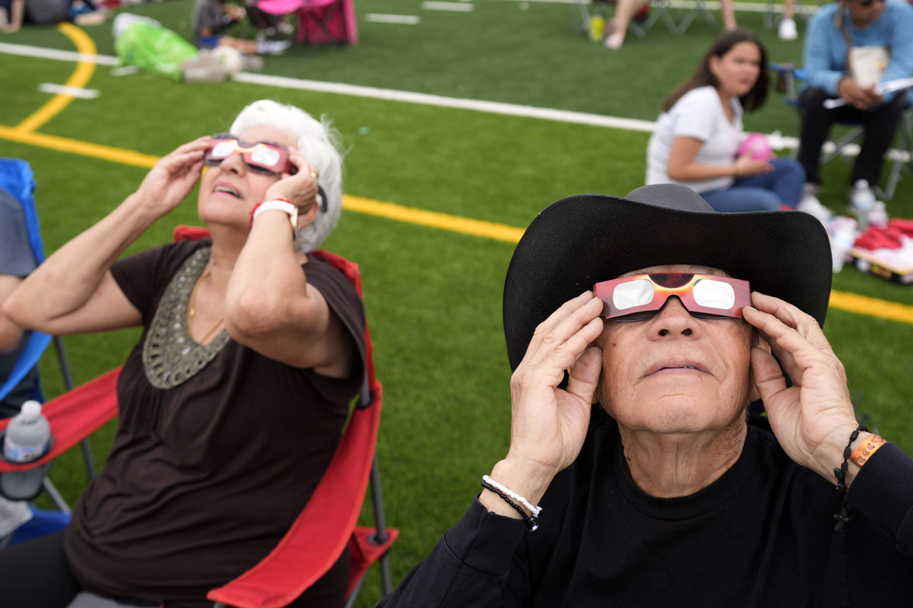 Al Angel Flores, right, watches as the moon partially covers the sun during a total solar eclipse, as seen from Eagle Pass, Texas. (Eric Gay/AP)