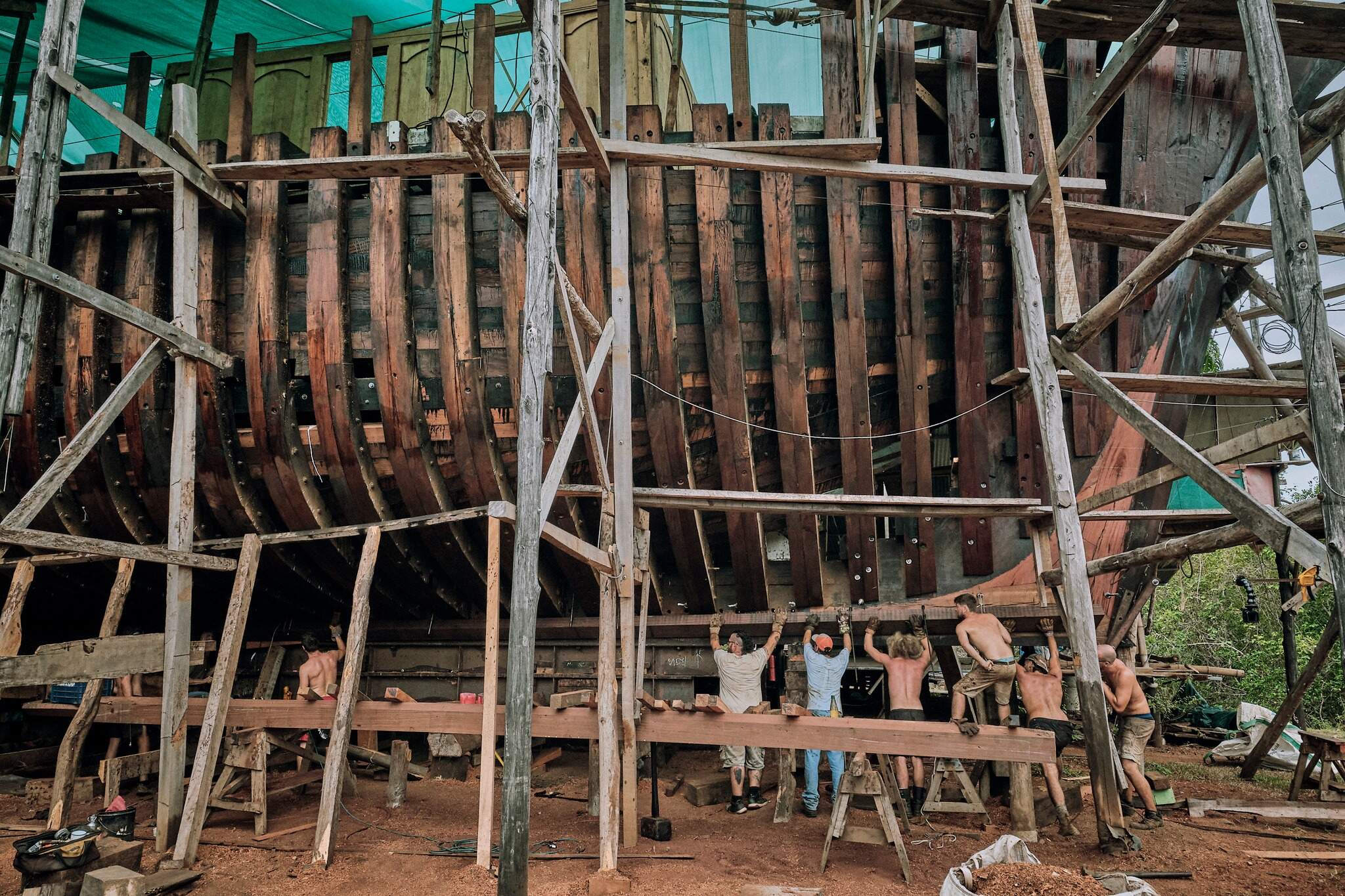 Workers building Sail Cargo’s wooden sailing vessel at a shipyard in Punta Morales, Costa Rica. (Courtesy of Sail Cargo)