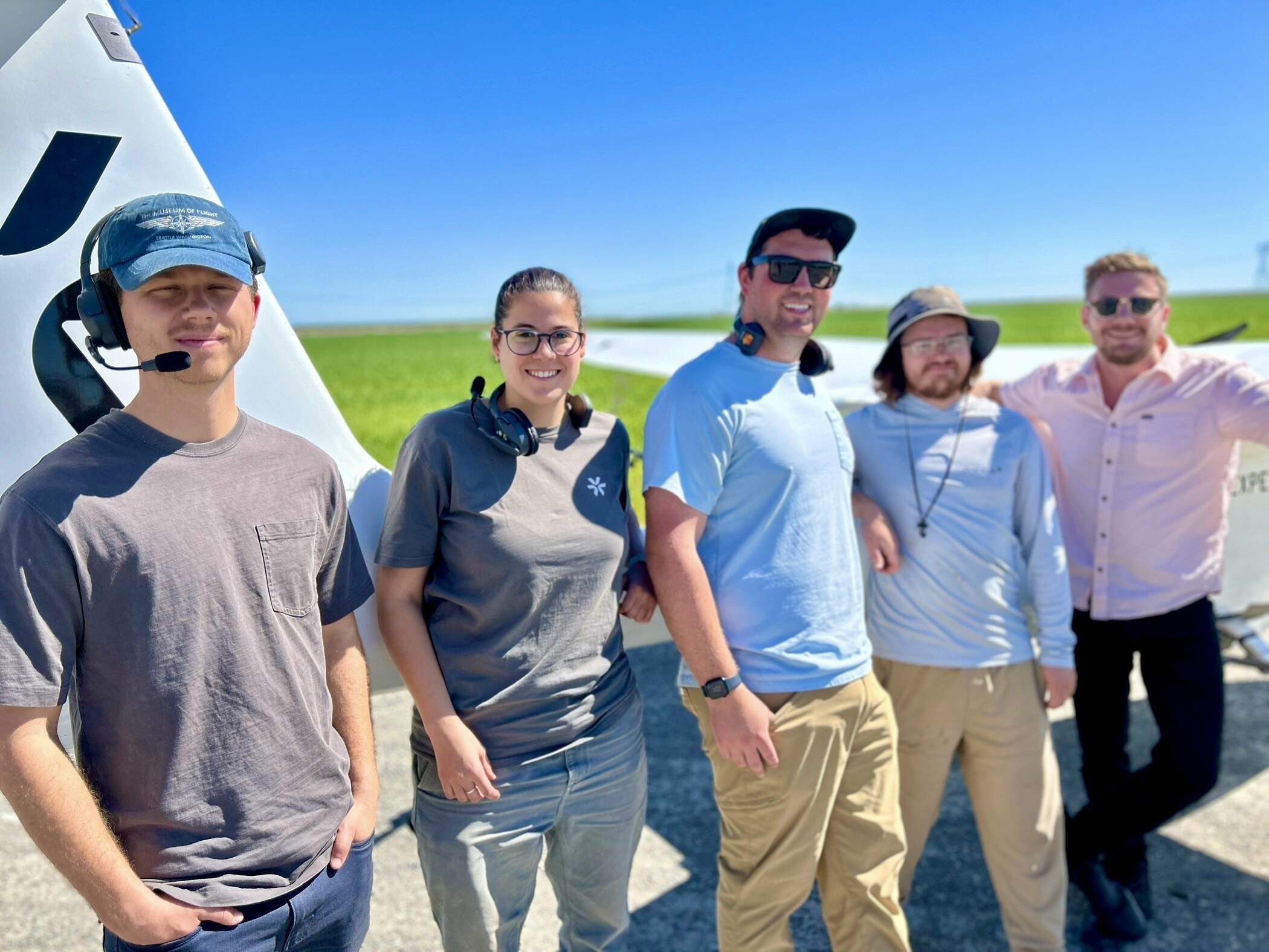 A crew from the California-based company Pyka stands in front of an autonomous electric aircraft after a demonstration flight. (Peter O'Dowd/Here &amp; Now)