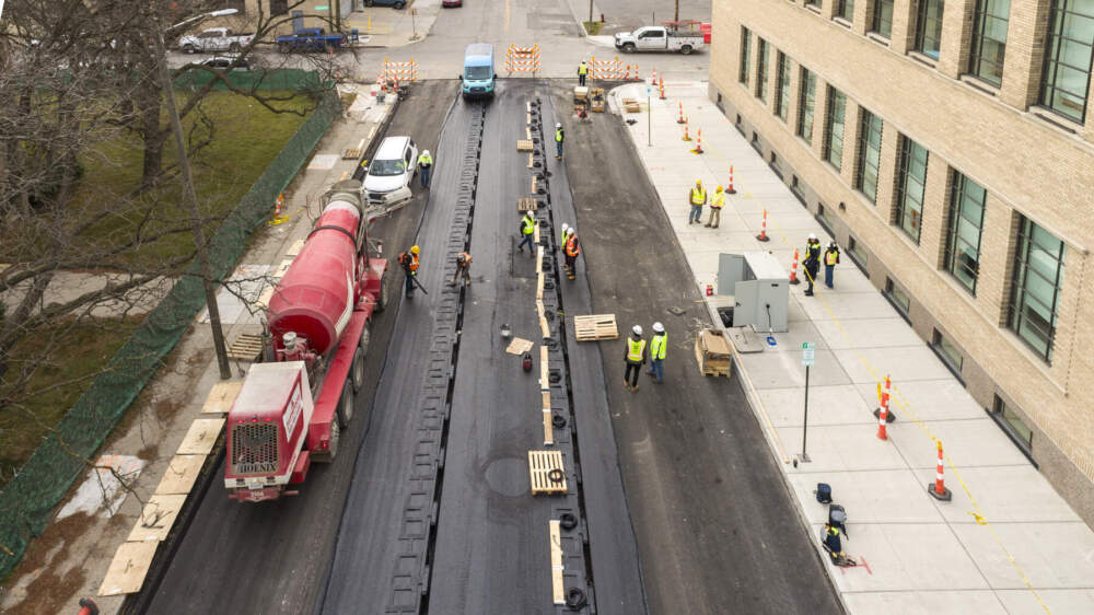 Workers installing a quarter-mile stretch of 14th Street in Detroit that can wirelessly charge vehicles as they drive down it. (Courtesy of MDOT Photo Services)