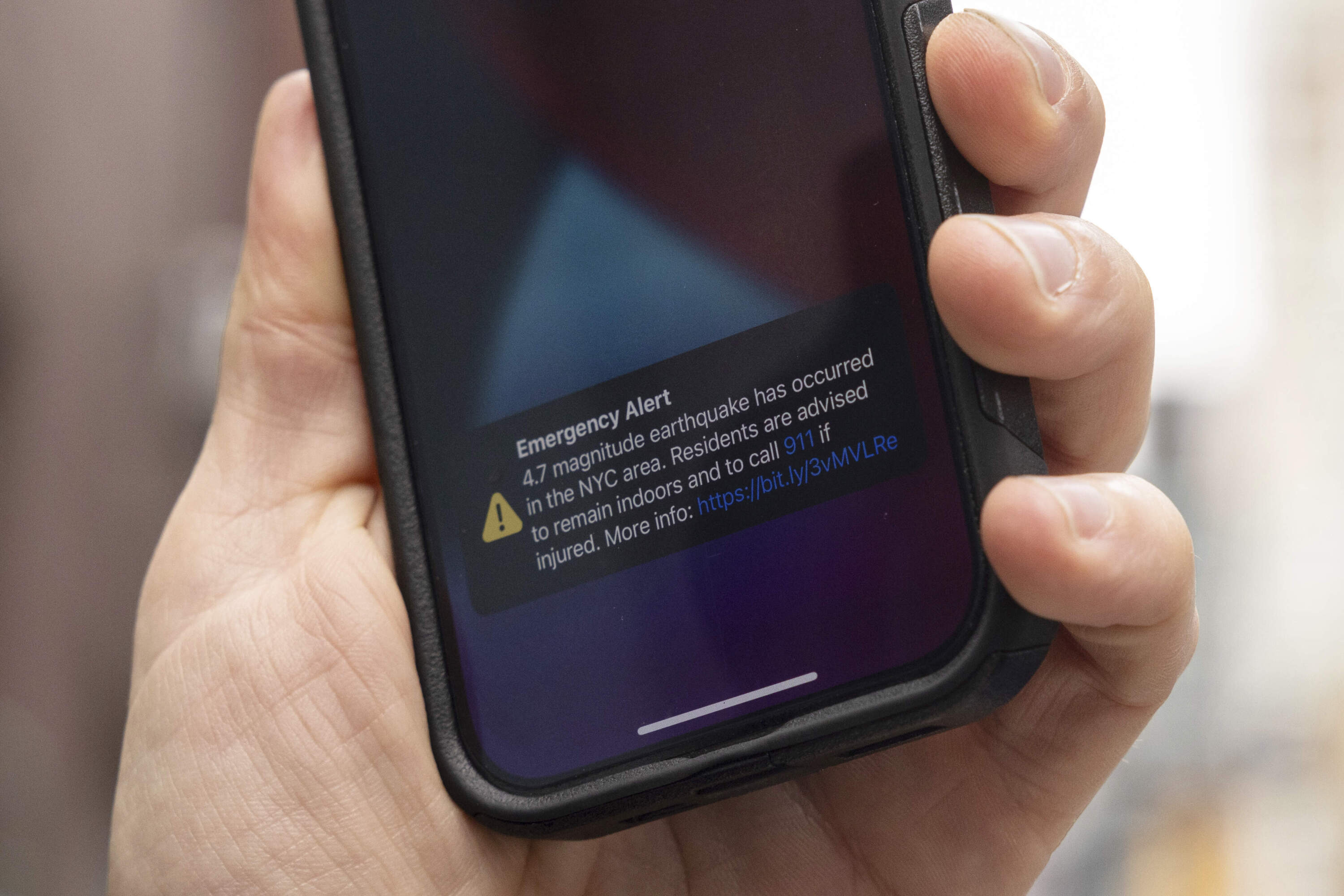A person looks at an emergency alert on their smartphone Friday, April. 5, 2024, in New York. An earthquake shook the densely populated New York City metropolitan area. (Yuki Iwamura/AP)