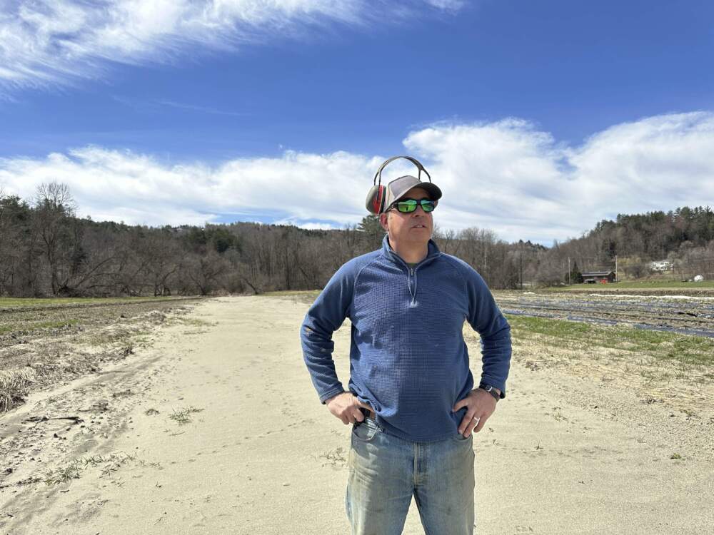Farmer George Gross, of Dog River Farm in Berlin, Vt., stands in a field covered with silt from flooding. (Lisa Rathke/AP)