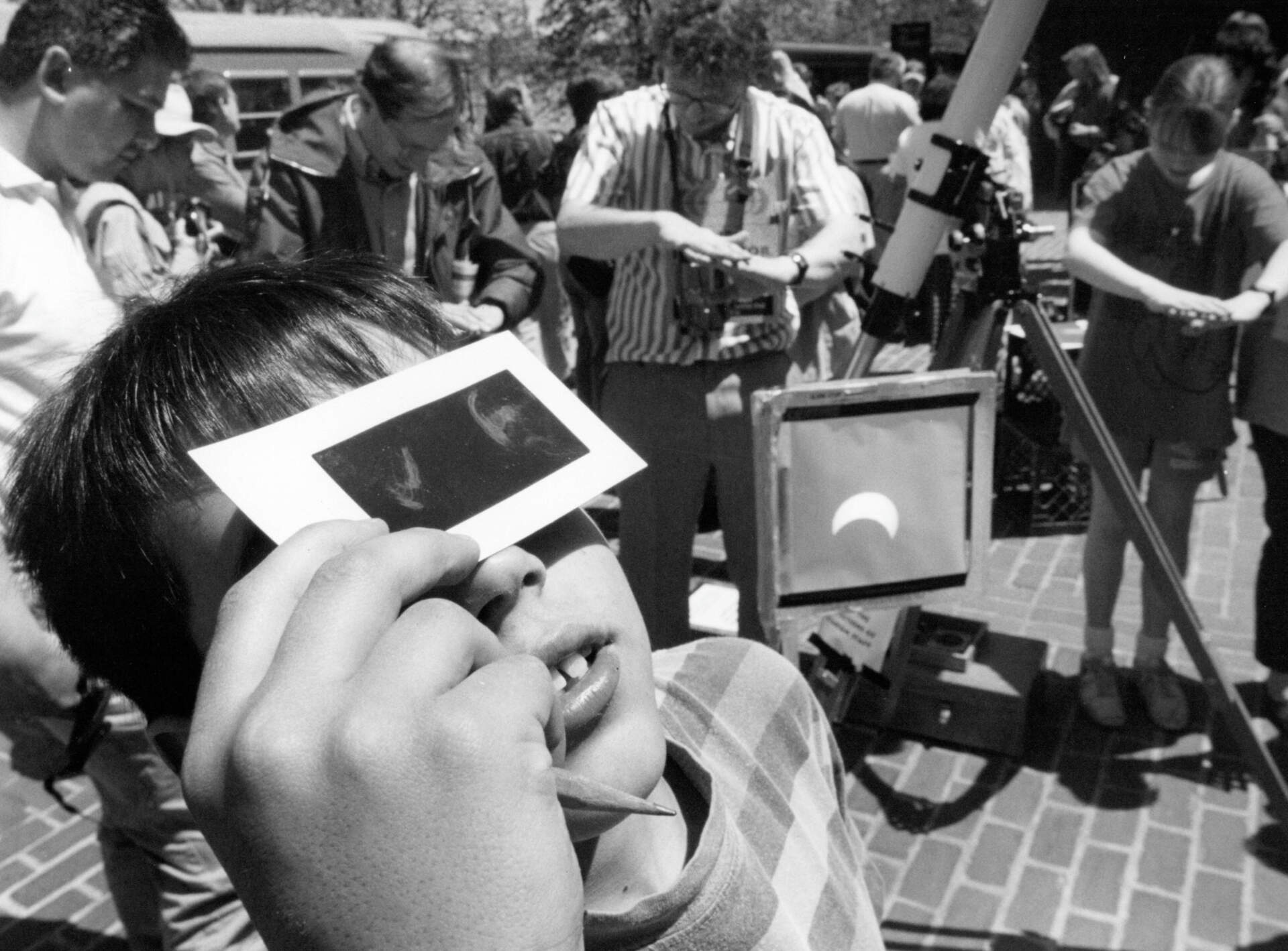 A young boy looks at the annular solar eclipse of 1994 through a filter outside the Boston Museum of Science. (David L. Ryan/The Boston Globe via Getty Images)