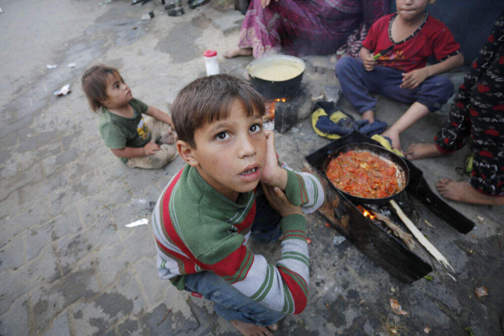 Palestinian children wait next to a fire as people prepare food for iftar (break fasting meal) during the holy month of Ramadan amid dramatic hunger on April 03, 2024. (Ashraf Amra/Anadolu via Getty Images)