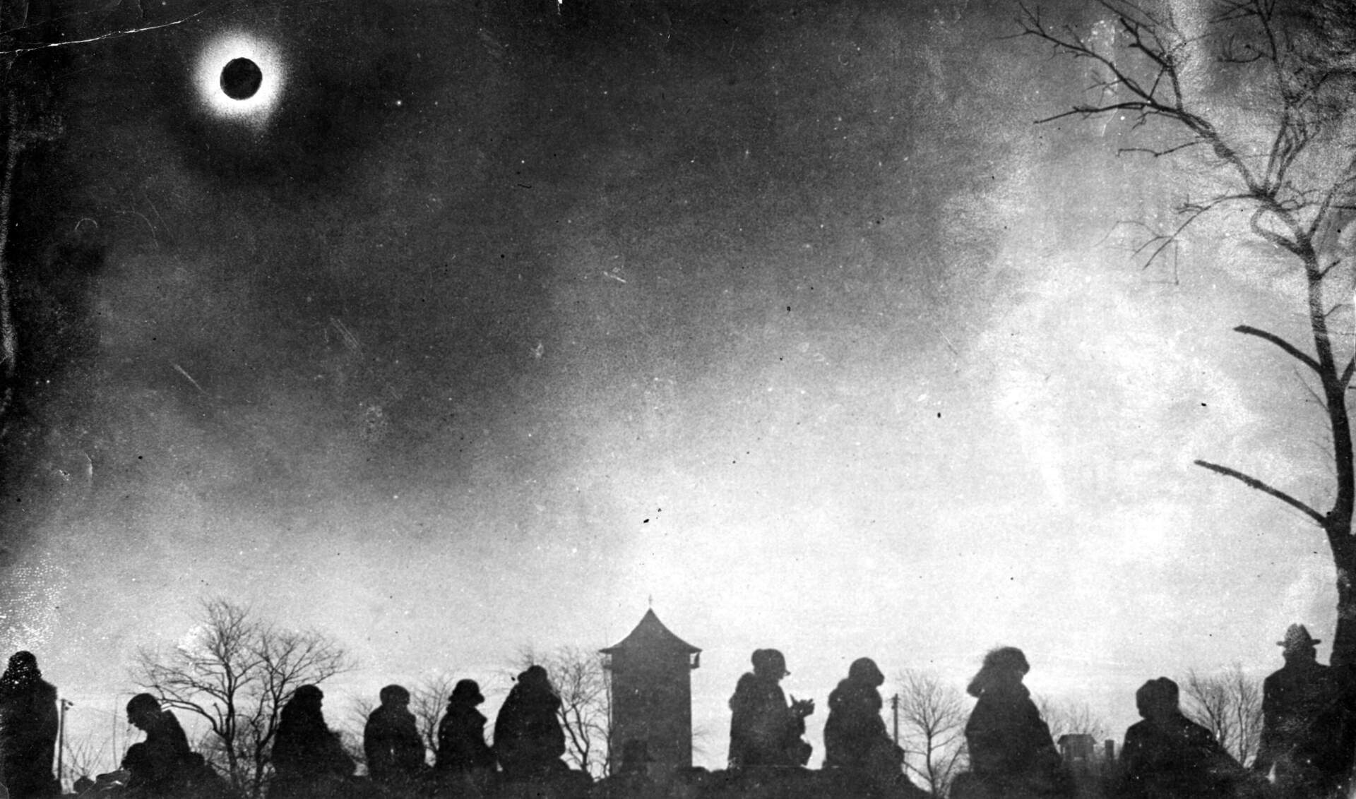 A group of people gathered in zero degree weather to watch the solar eclipse, showing the corona, at Vose Field in Westerly, Rhode Island, at around 9:30 a.m., on Jan. 24, 1925. An estimated 10,000 visitors came to watch the event. (James L. Callahan/The Boston Globe via Getty Images)
