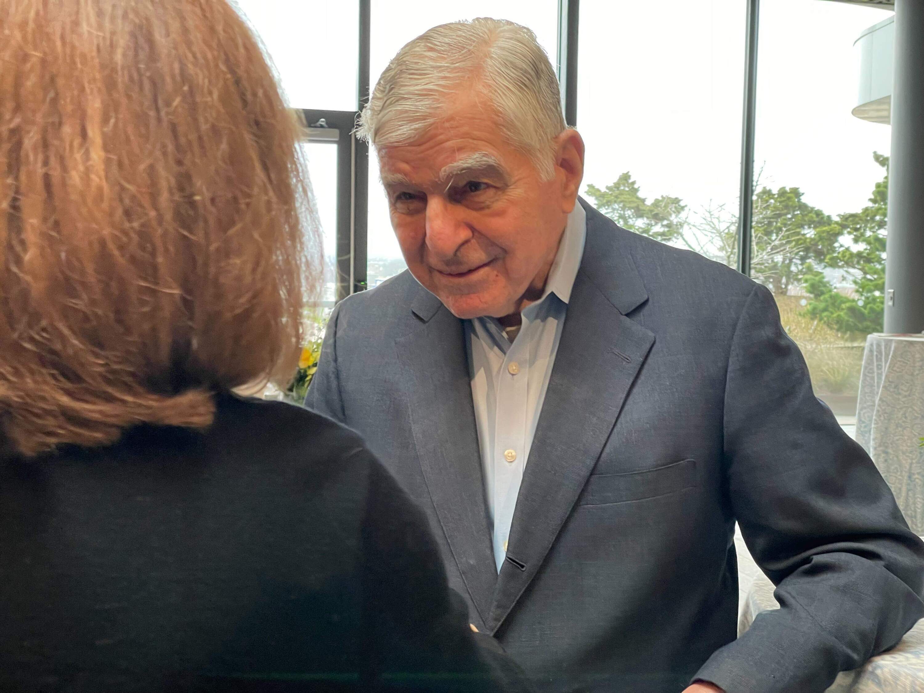 Former Gov. Michael Dukakis speaks with an attendee at his Northeastern University retirement ceremony. (Max Larkin/WBUR)