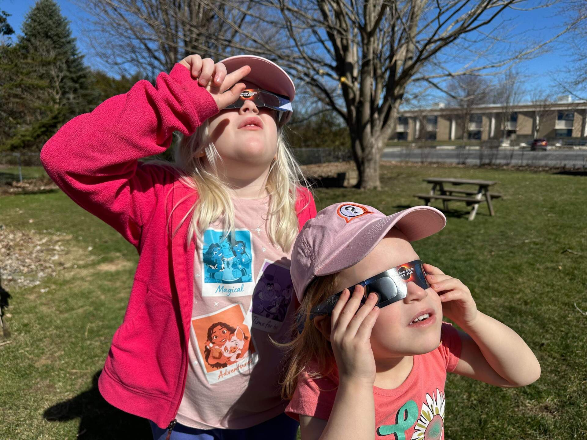 Maggie Miller, 6 and Libby Miller, 4, practice wearing eclipse glasses in Saint Albans., Vt. (Katie Miller/Vermont Public)