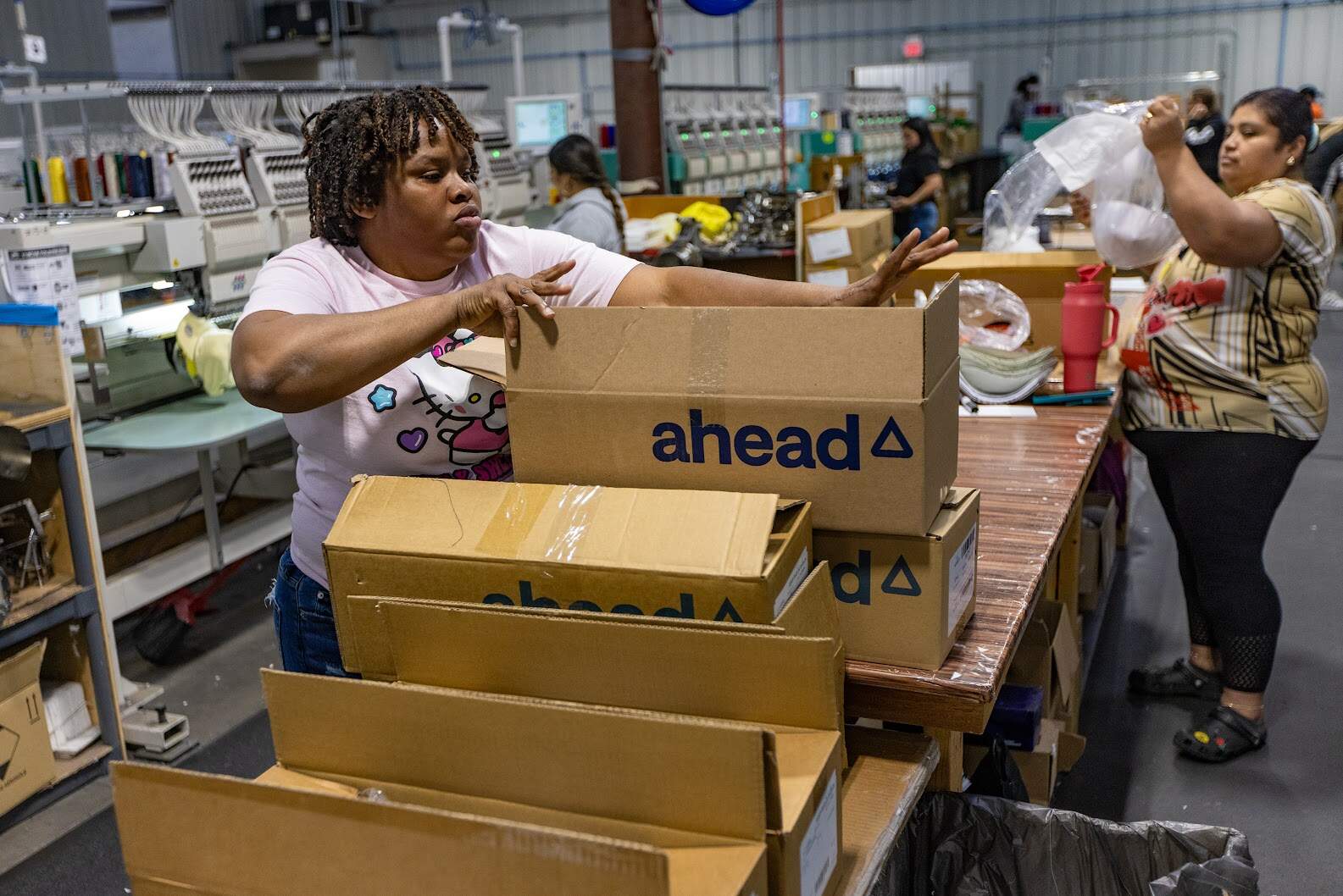Musette Jean-Pierre packs a box of hats to be shipped off to customers. (Jesse Costa/WBUR)