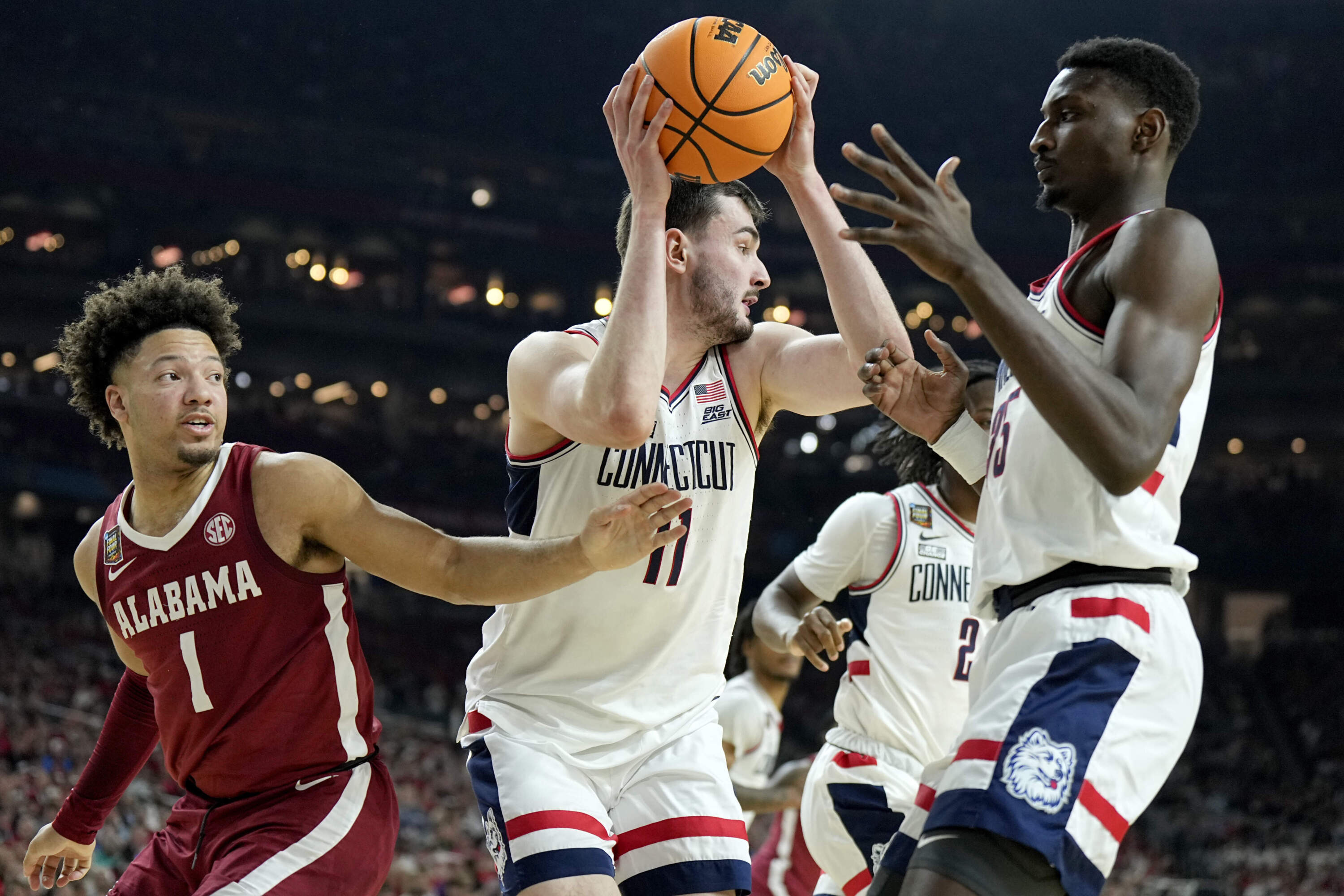 UConn forward Alex Karaban (11) pulls down a rebound as Alabama guard Mark Sears (1) defends during the second half of the NCAA college basketball game at the Final Four. (Brynn Anderson/AP)