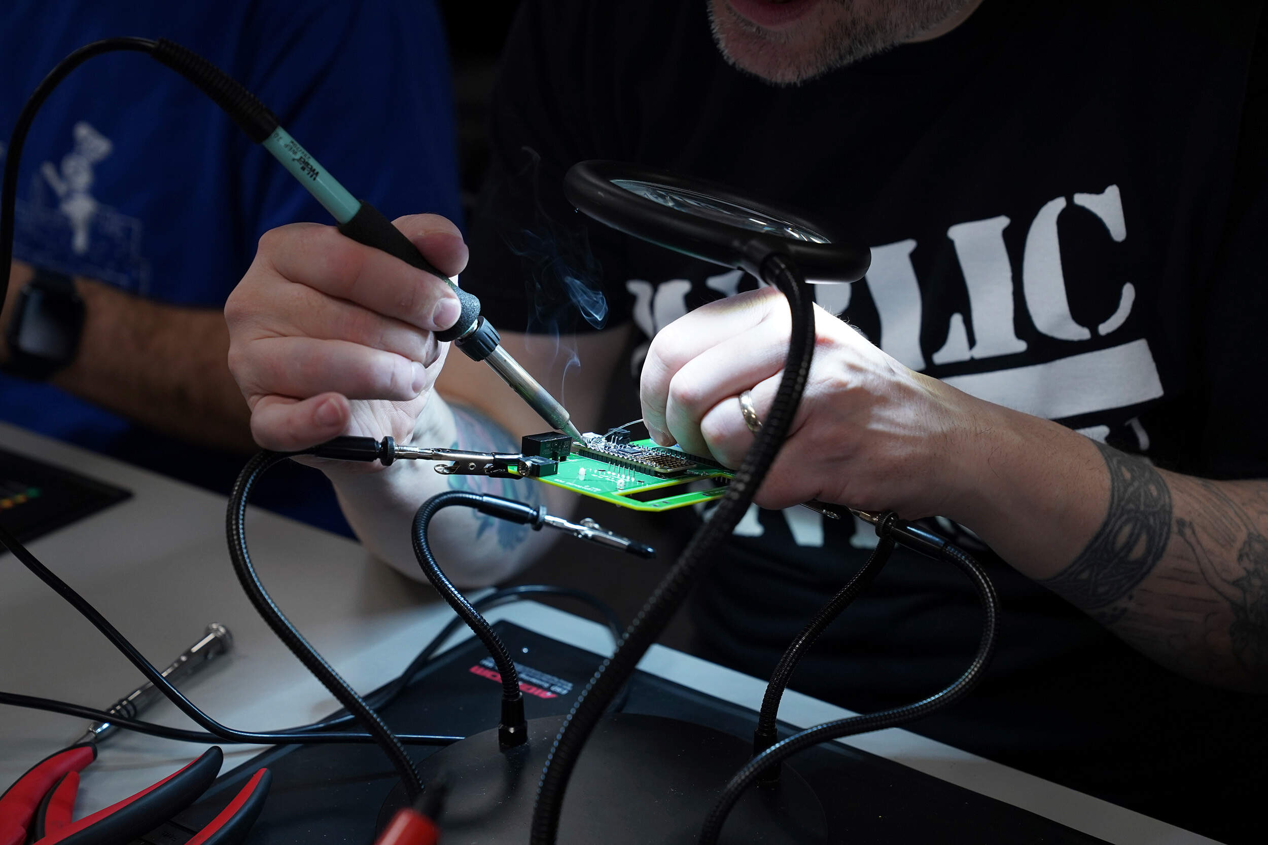 A workshop participant solders components for a LightSound device at the New England Sci-Tech education center in Natick, Mass. (Mary Conlon/AP)