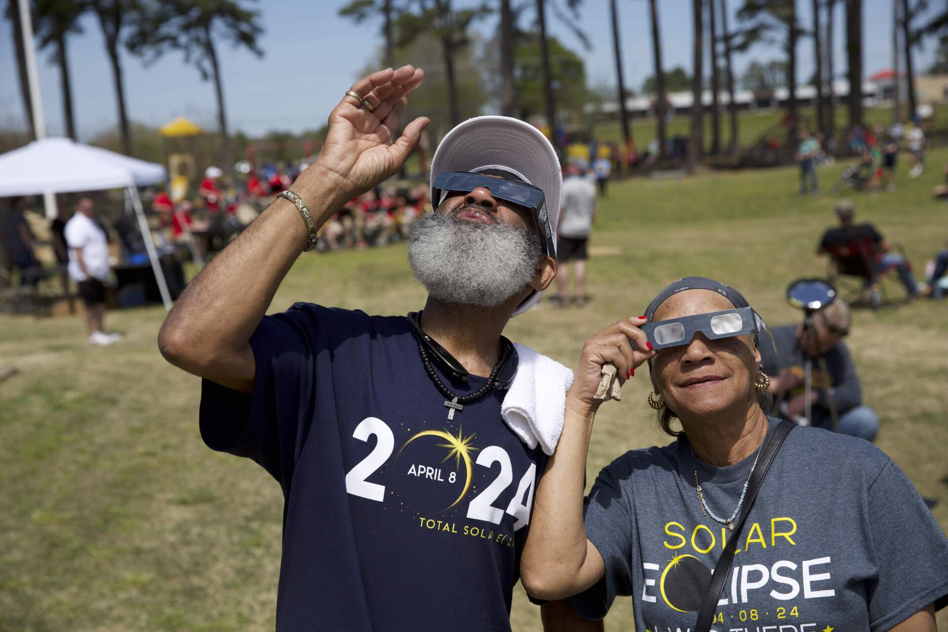 As the eclipse begins, Billy Mills and Bertha Cain look up amidst the festivities at Berryhill Park in Searcy, AR. (Nick Michael/NPR)