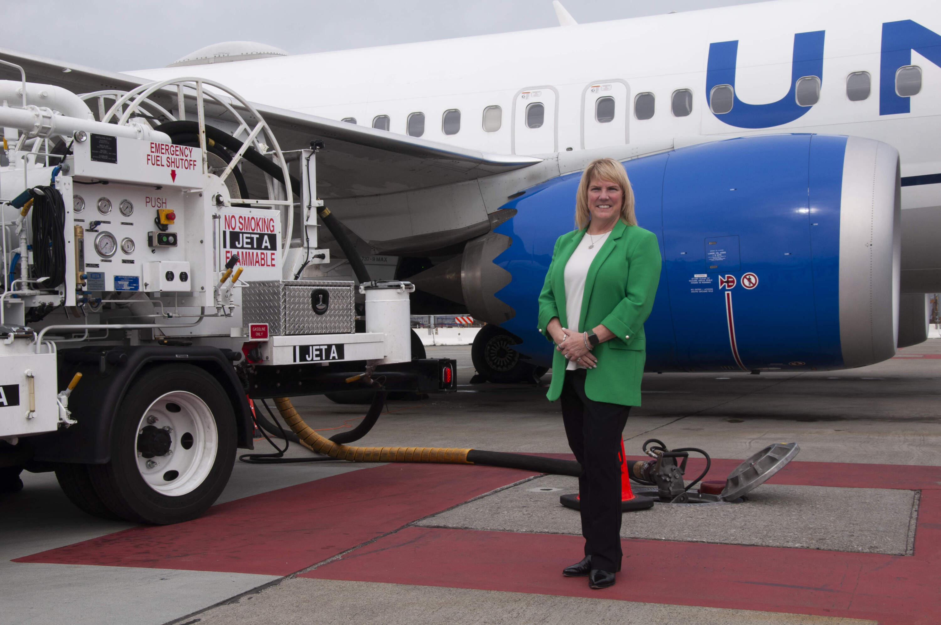 Lori Augustine, vice president of the San Francisco International Airport Hub for United Airlines, with a refueling truck pumping sustainable aviation fuel at SFO. (Chris Bentley/Here &amp; Now)