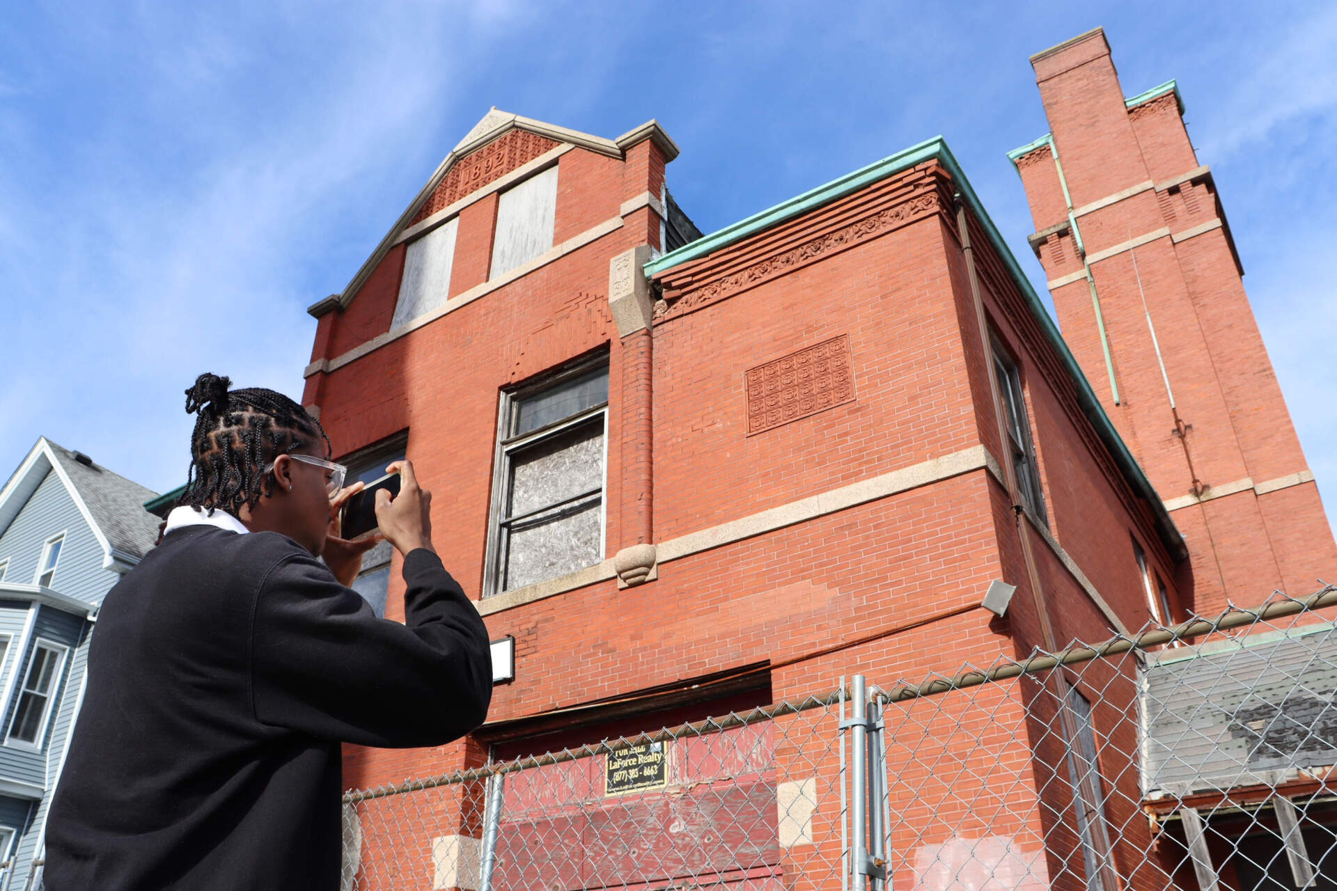 Jai Edward Blyden takes photos and videos of the Hillman Street Firehouse in New Bedford. Blyden is one of the architecture students who traveled 450 miles from Howard University in Washington D.C. to New Bedford to explore how they could breathe new life into the Hillman Street Firehouse. (Eve Zuckoff/CAI)