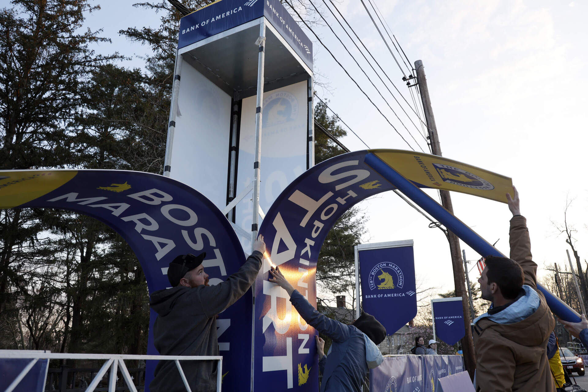 Workers affix banners at the starting line of the Boston Marathon on April 15, 2024, in Hopkinton, Mass. (Mary Schwalm/AP)