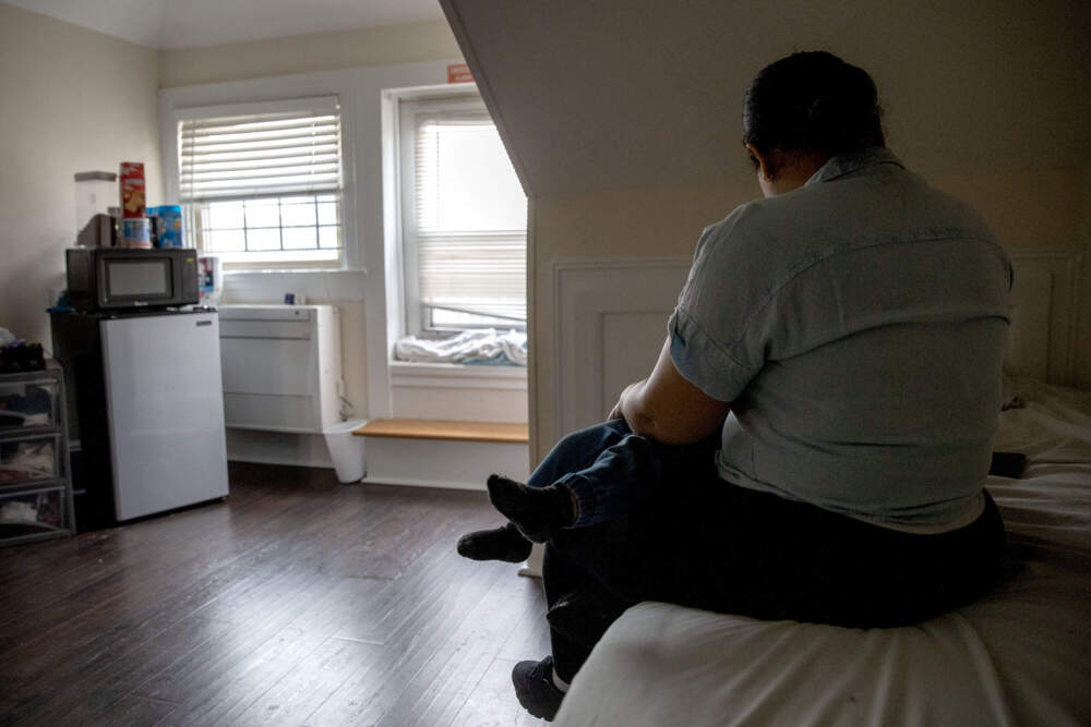 Ericka Guerrero and her son Leudi sit on the bed in their shelter room in Brookline. (Robin Lubbock/WBUR)