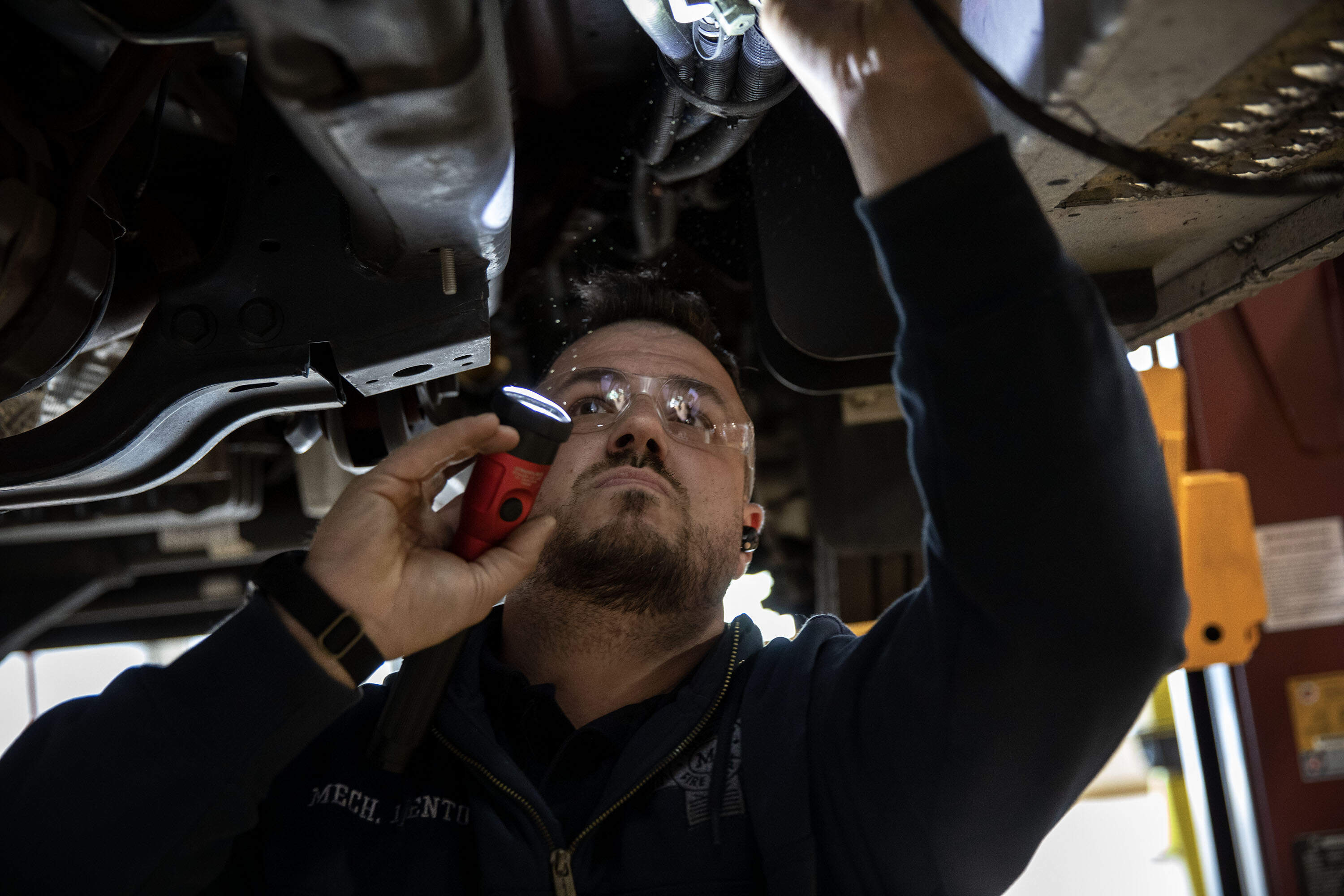 Norwood Fire mechanic Nicholas Lento examines an ambulance. (Robin Lubbock/WBUR)