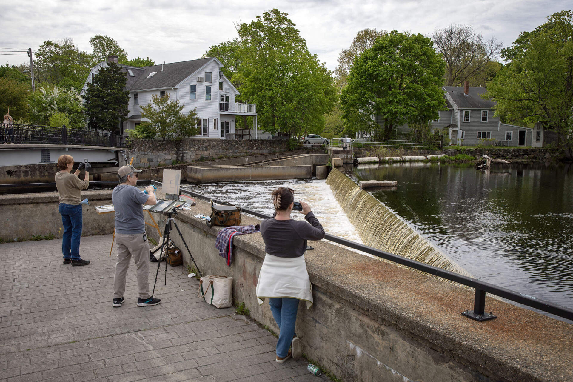 People stop to paint and photograph the Ipswich River as it flows over Ipswich Mills Dam. (Robin Lubbock/WBUR)