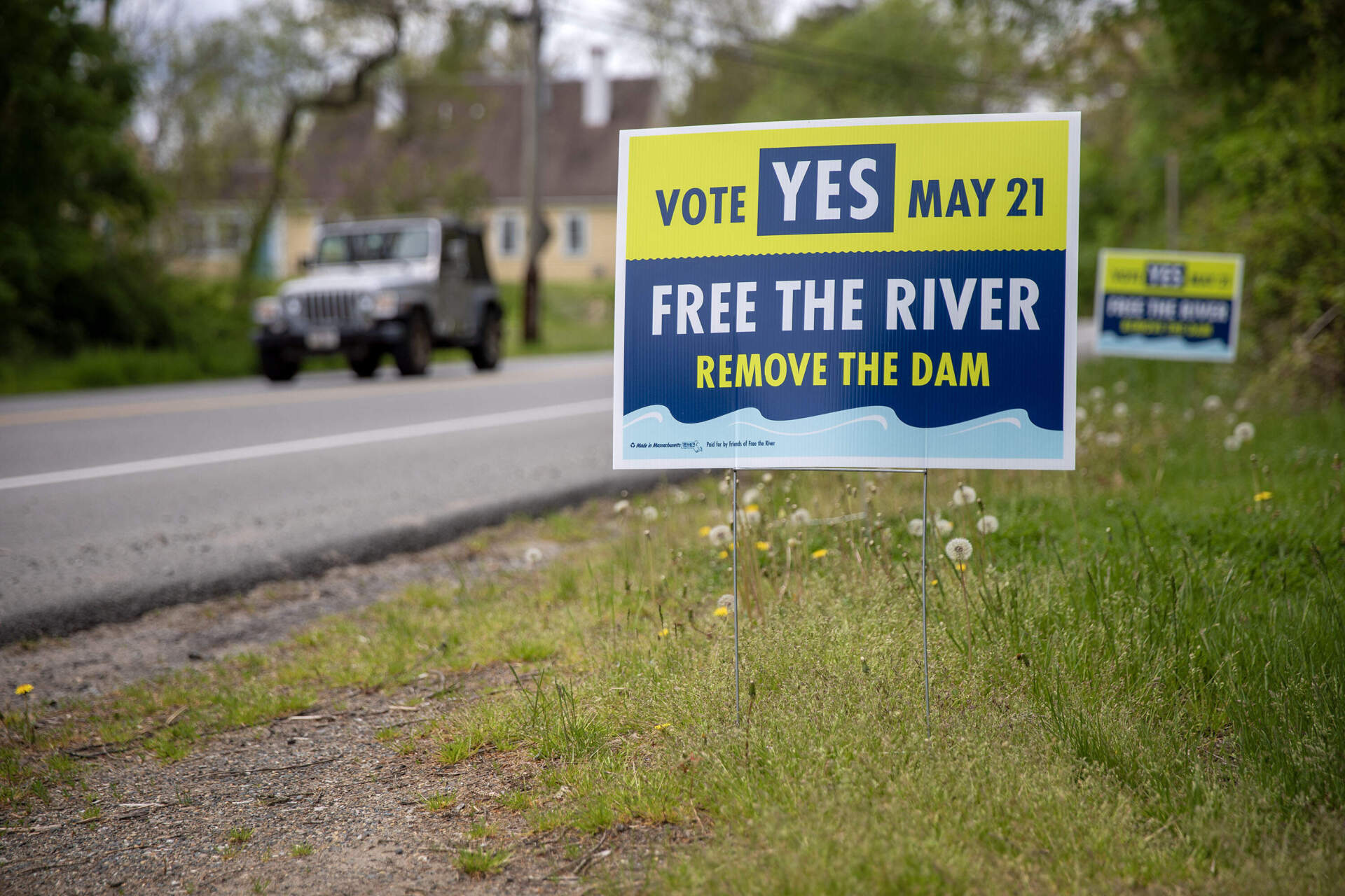 A campaign sign to remove the Ipswich Mills Dam stands at the side of the road in Ipswich. (Robin Lubbock/WBUR)