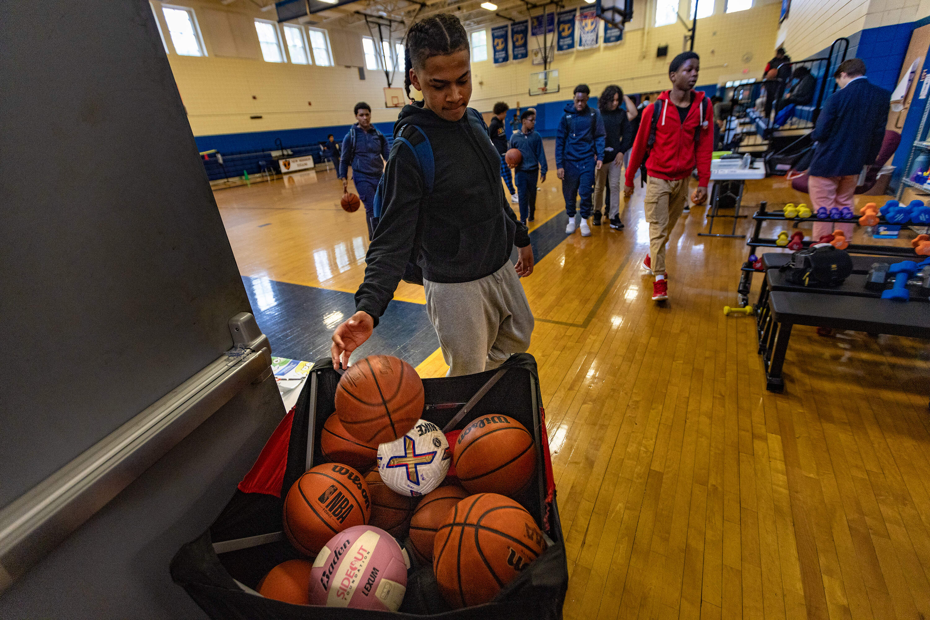Students file out and return basketballs after the school bell rings to signal the start of classes at New Mission High in Hyde Park. (Jesse Costa/WBUR)