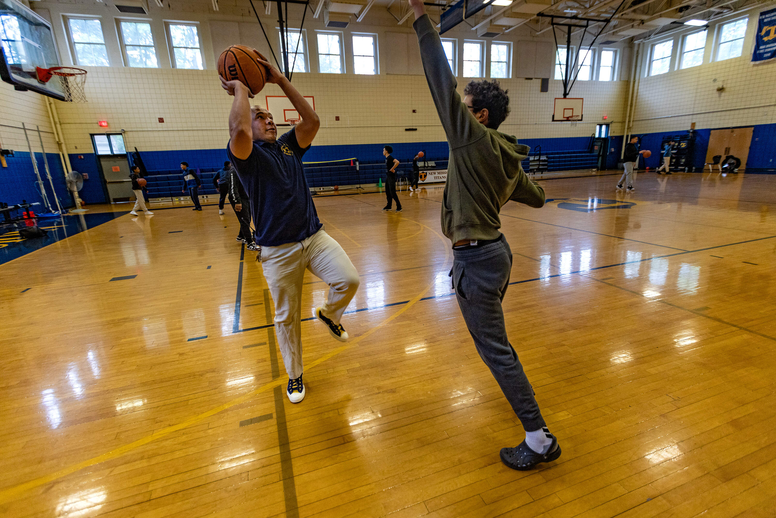 New Mission High School Principal William Thomas mixes it up in a one-on-one with a student during a “Win the Day” intramural sports program before the start of class. (Jesse Costa/WBUR)