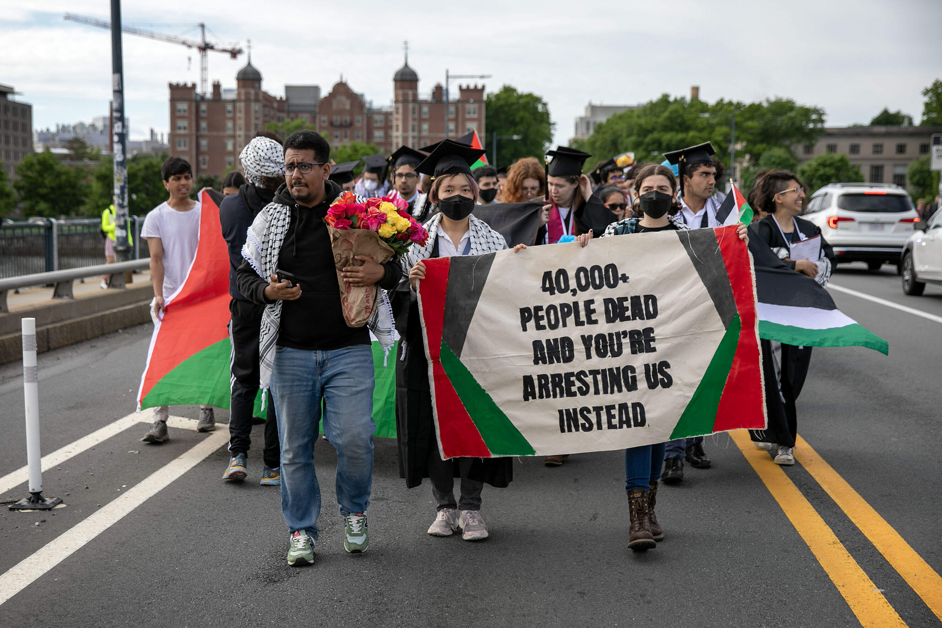 Protesters from MIT's commencement ceremony cross the Charles River heading toward Boston. (Robin Lubbock/WBUR)