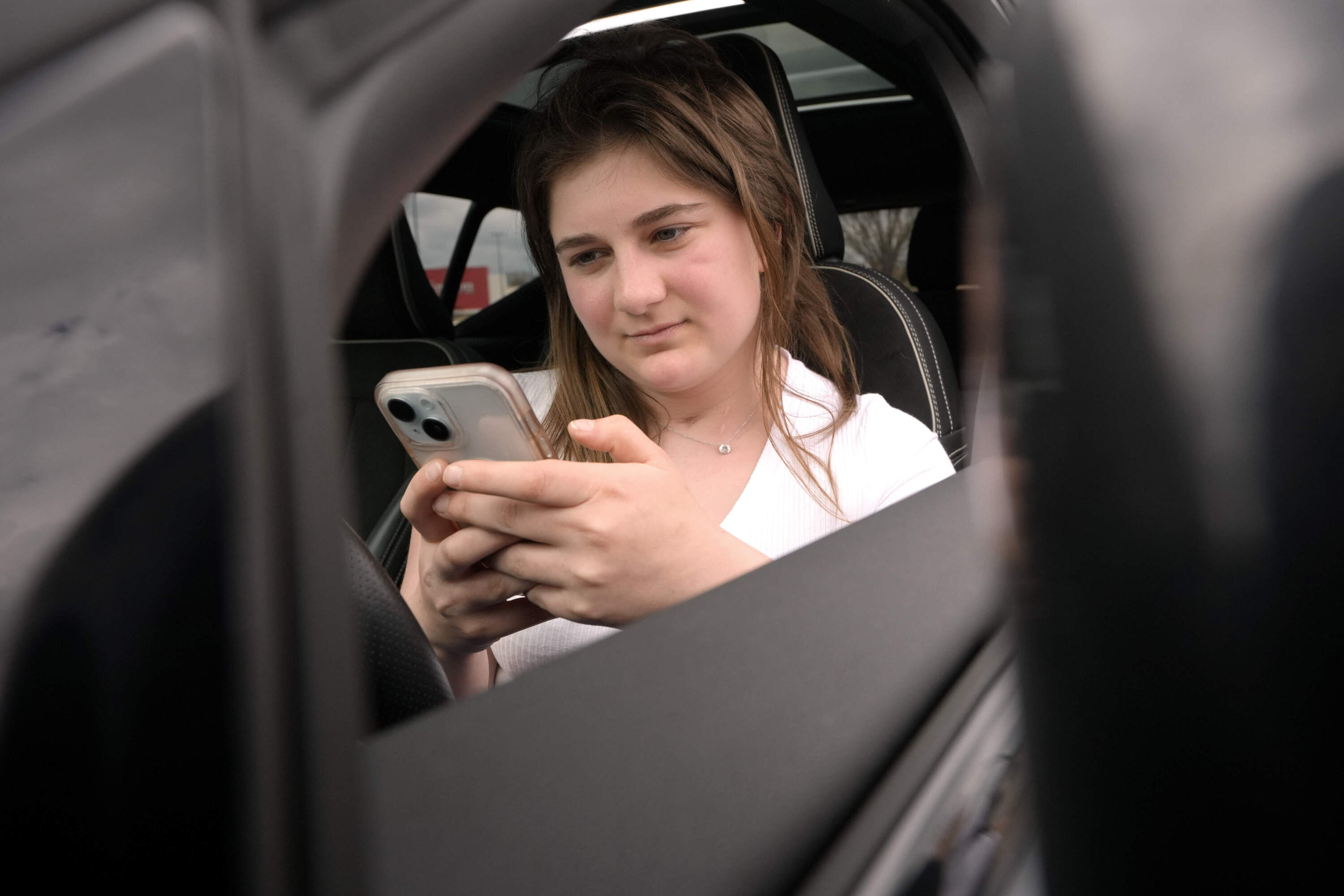 Alexis Bogan, whose speech was impaired by a brain tumor, uses an AI powered smartphone app to create a audible drink order at a Starbucks drive-thru on Monday, April 29, 2024. (Steven Senne/AP)
