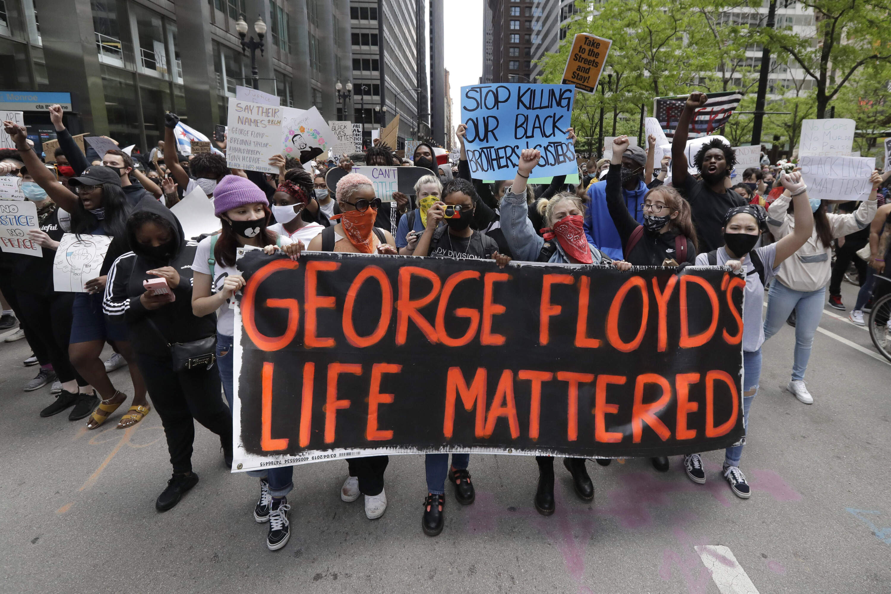 Protesters hold signs as they march during a protest over the death of George Floyd in Chicago. (Nam Y. Huh/AP)