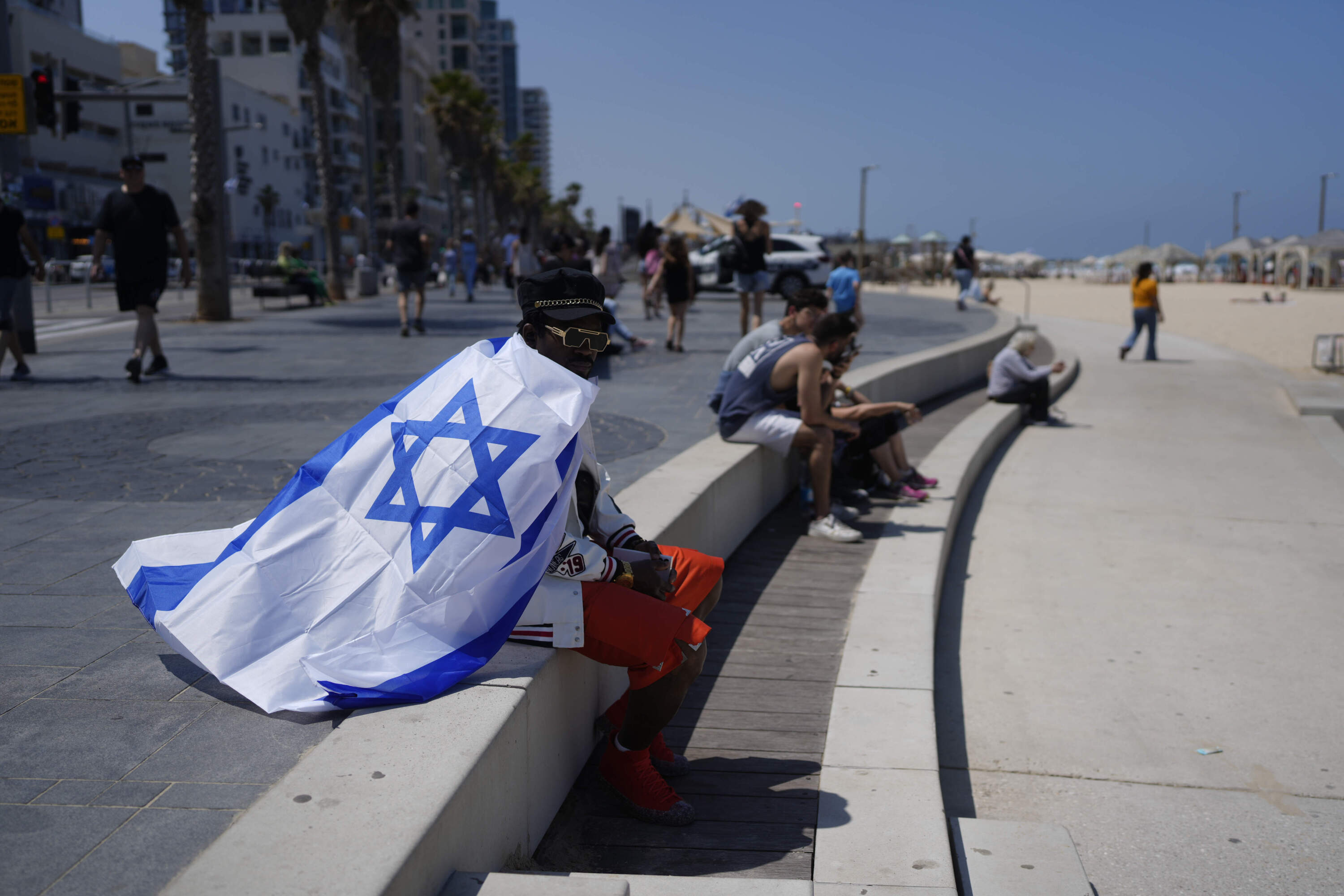 Draped in an Israeli flag, a man sits on the edge of a beach during Israel's Independence Day celebrations in Tel Aviv. (Ohad Zwigenberg/AP)Draped in an Israeli flag, a man sits on the edge of a beach during Israel's Independence Day celebrations in Tel Aviv. (Ohad Zwigenberg/AP)