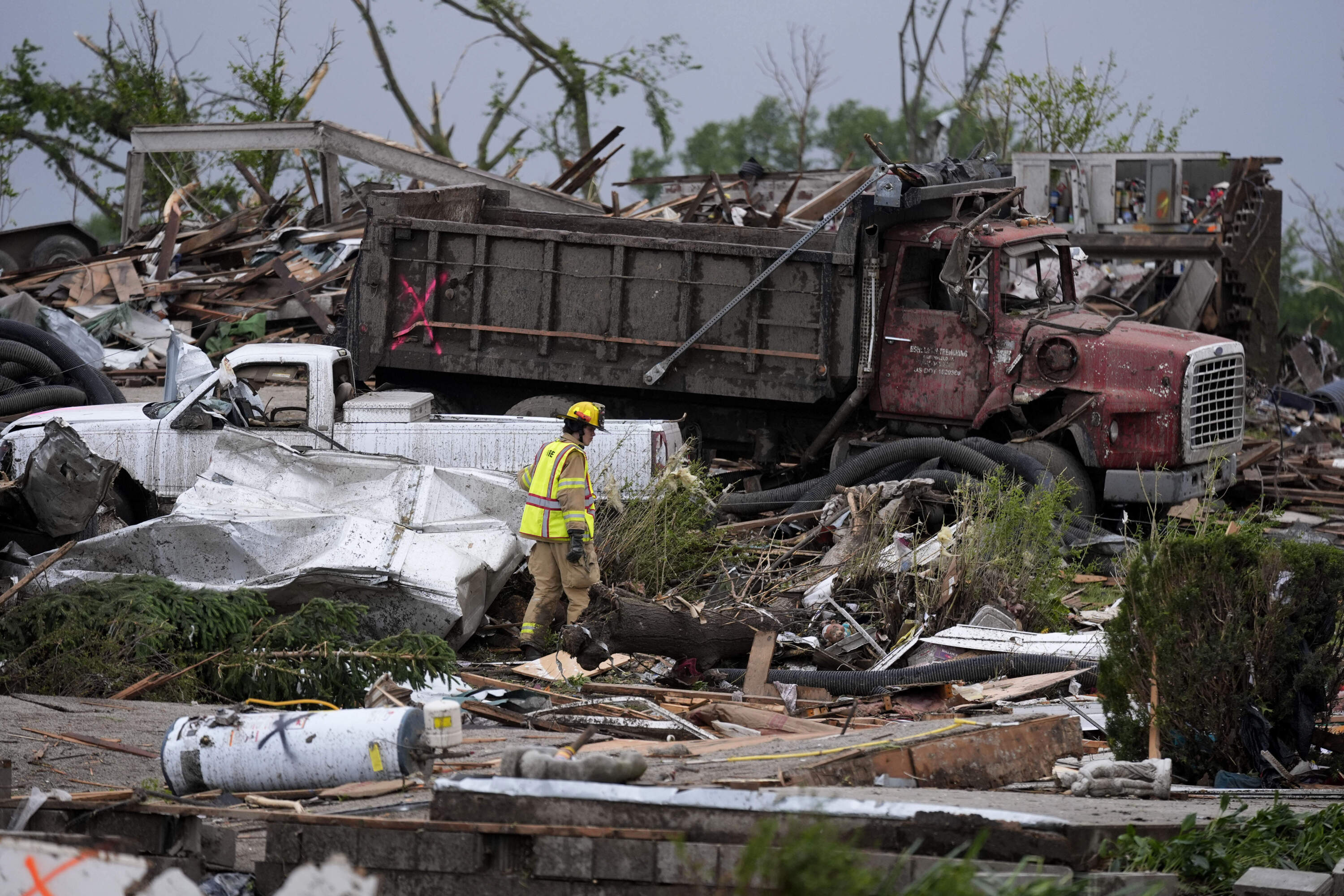 A firefighter walks among homes destroyed by a tornado in Greenfield, Iowa. (Charlie Neibergall/AP)
