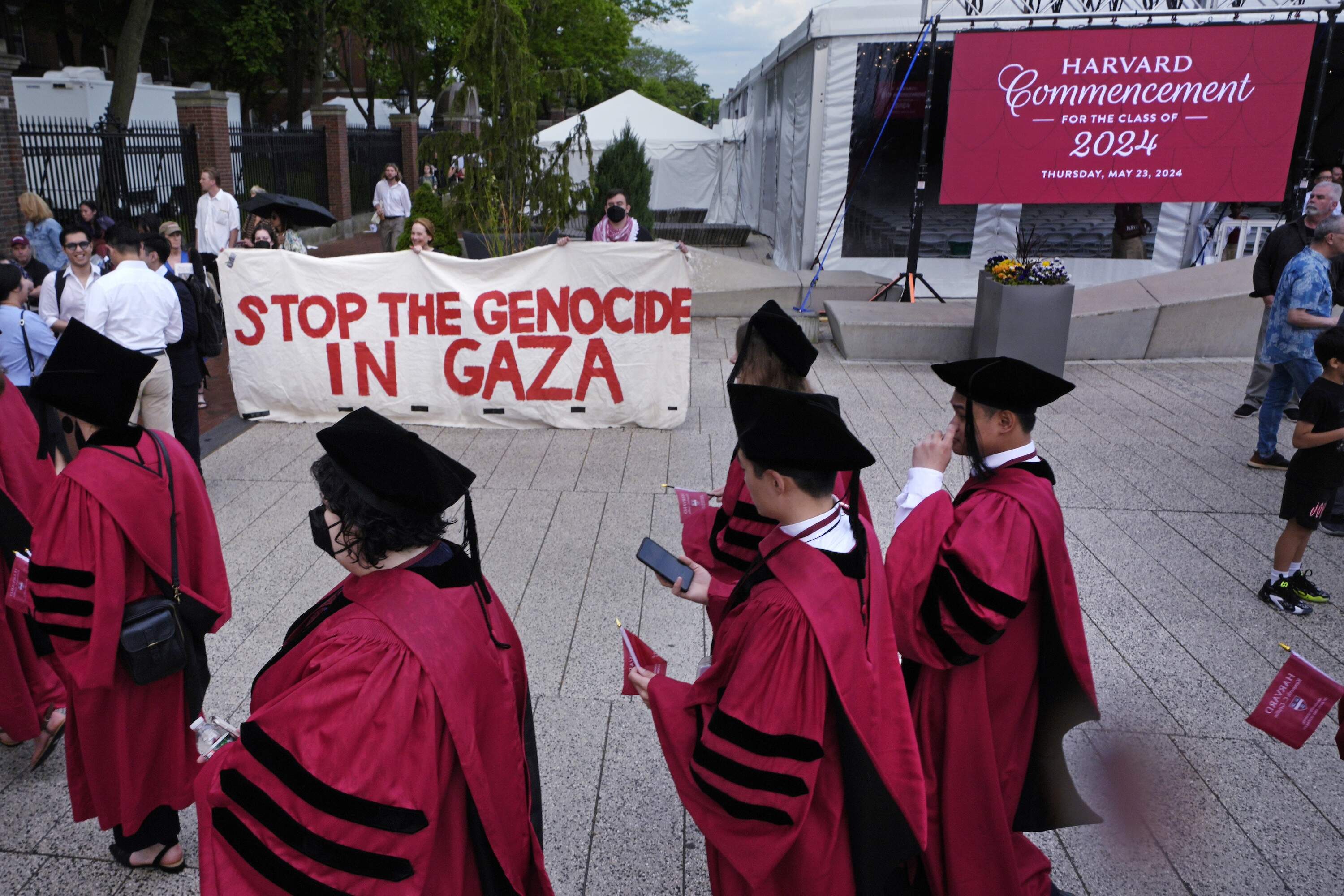 Harvard University students pass protestors while filing into Harvard Yard for commencement at Harvard University, Thursday, May 23, 2024, in Cambridge, Mass. (Charles Krupa/AP)