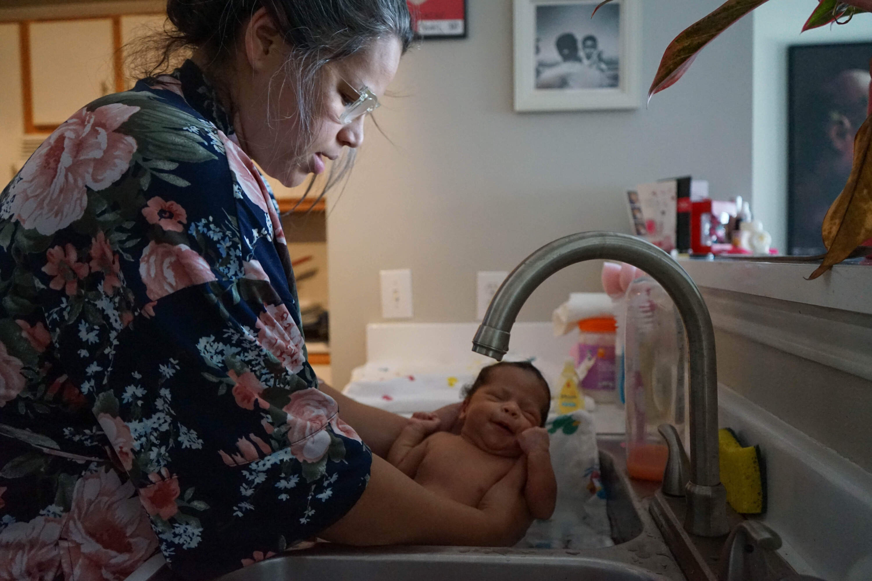 Catherina Lawson bathes her infant Avella Lawson in the kitchen sink. (Courtesy Stefanie D. Belnavis/Birthlooms)