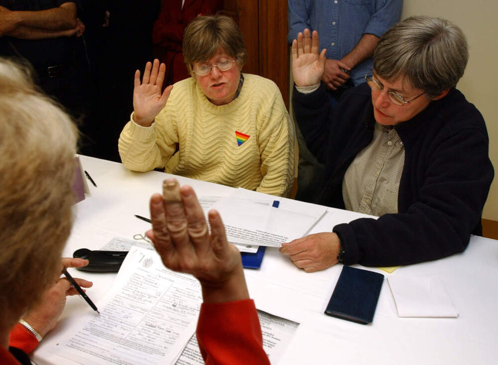 Marcia Hams, center, and her partner Susan Shepherd, right, both of Cambridge, Mass., raise their hands to take an oath administered by City Clerk D. Margaret Drury, left, at Cambridge City Hall, in Cambridge, as they participate in the application process for a marriage license several minutes after midnight Monday, May 17, 2004. Hams and Shepherd were the first couple to begin the application process as Massachusetts became the first state to legalize same-sex unions in the United States. (Steven Senne/AP)