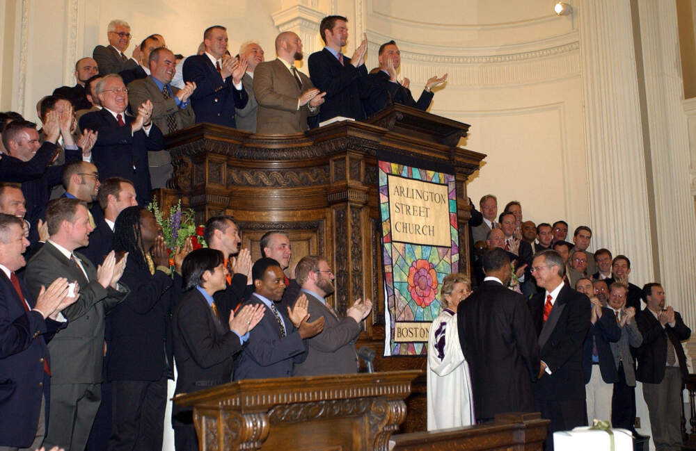 Members of the Boston Gay Men's Chorus applaud as Unitarian Rev. Kim Crawford Harvie (in white robe) announces she is able to legally marry David Wilson and Robert Compton (facing each other in front of Rev. Harvie), May 17, 2004, at Arlington Street Church in Boston, Massachusetts. Wilson and Compton joined with 12 other plaintiffs in the court case that legalized gay marriage in Massachusetts.(Stan Honda via Getty Images)