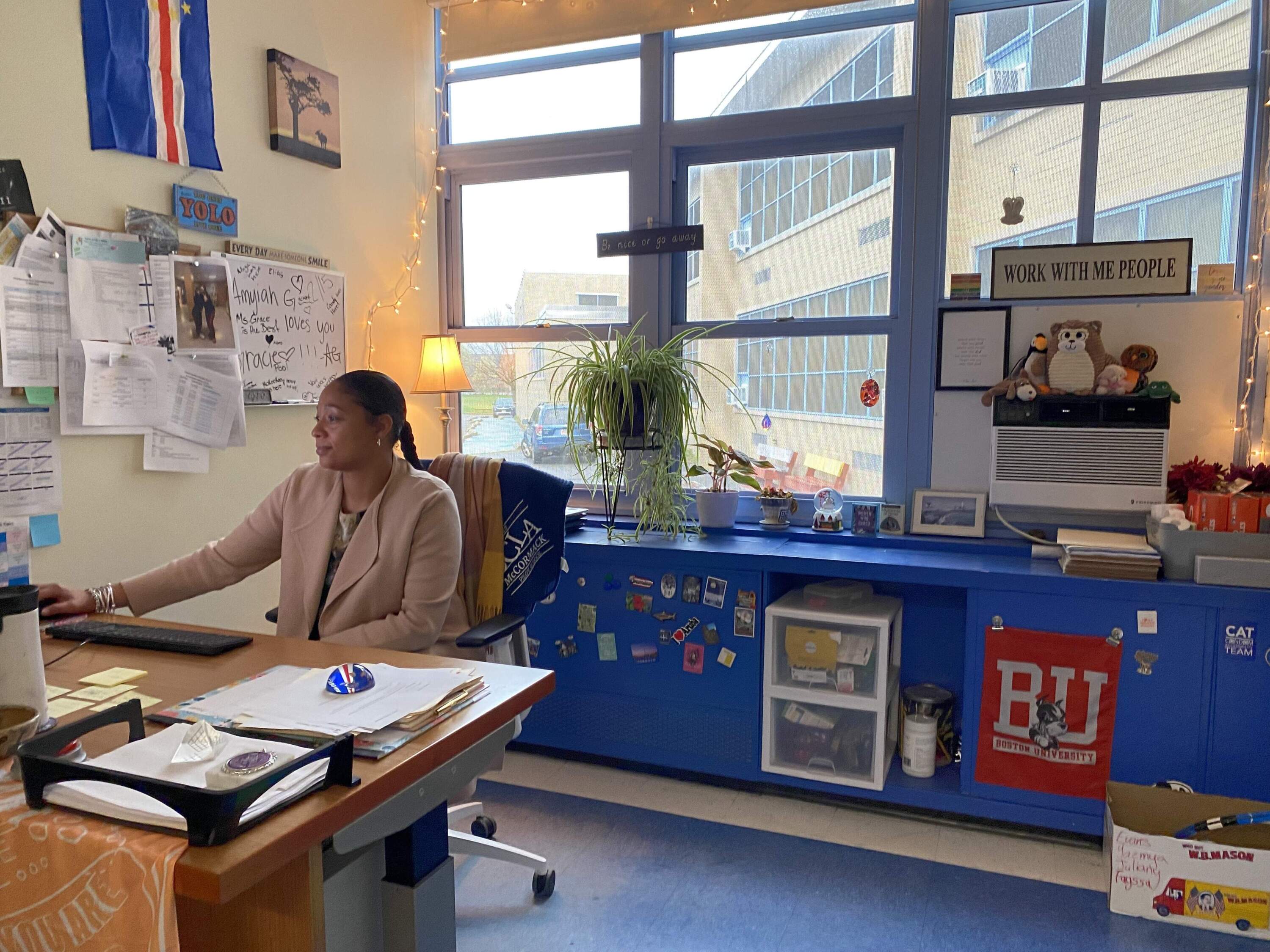 School counselor Justine Grace sits at her desk at the BCLA-McCormack Academy in Dorchester. She works with kids to target reasons for absences.