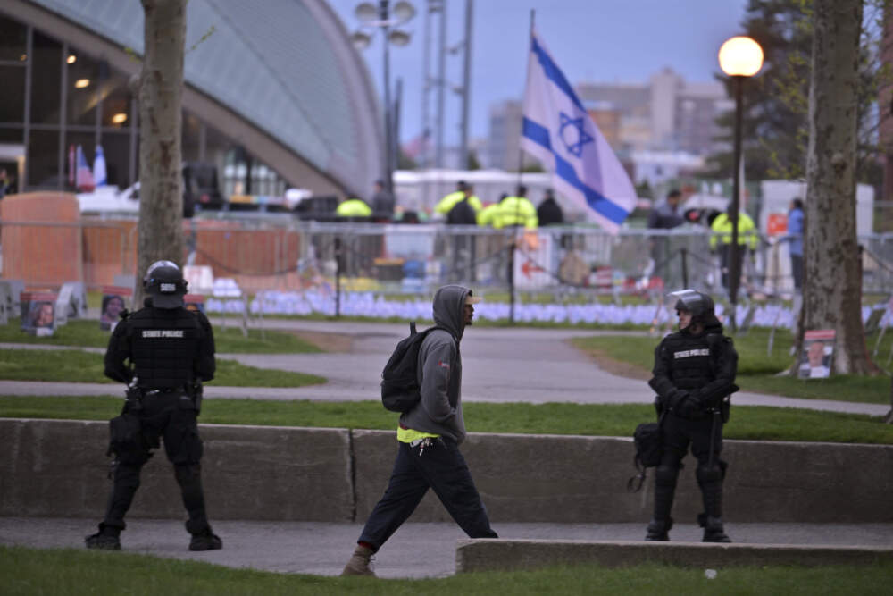 A man walks by a perimeter of police in riot gear as police dismantle the pro-Palestinian encampment at MIT. (Josh Reynolds/AP)